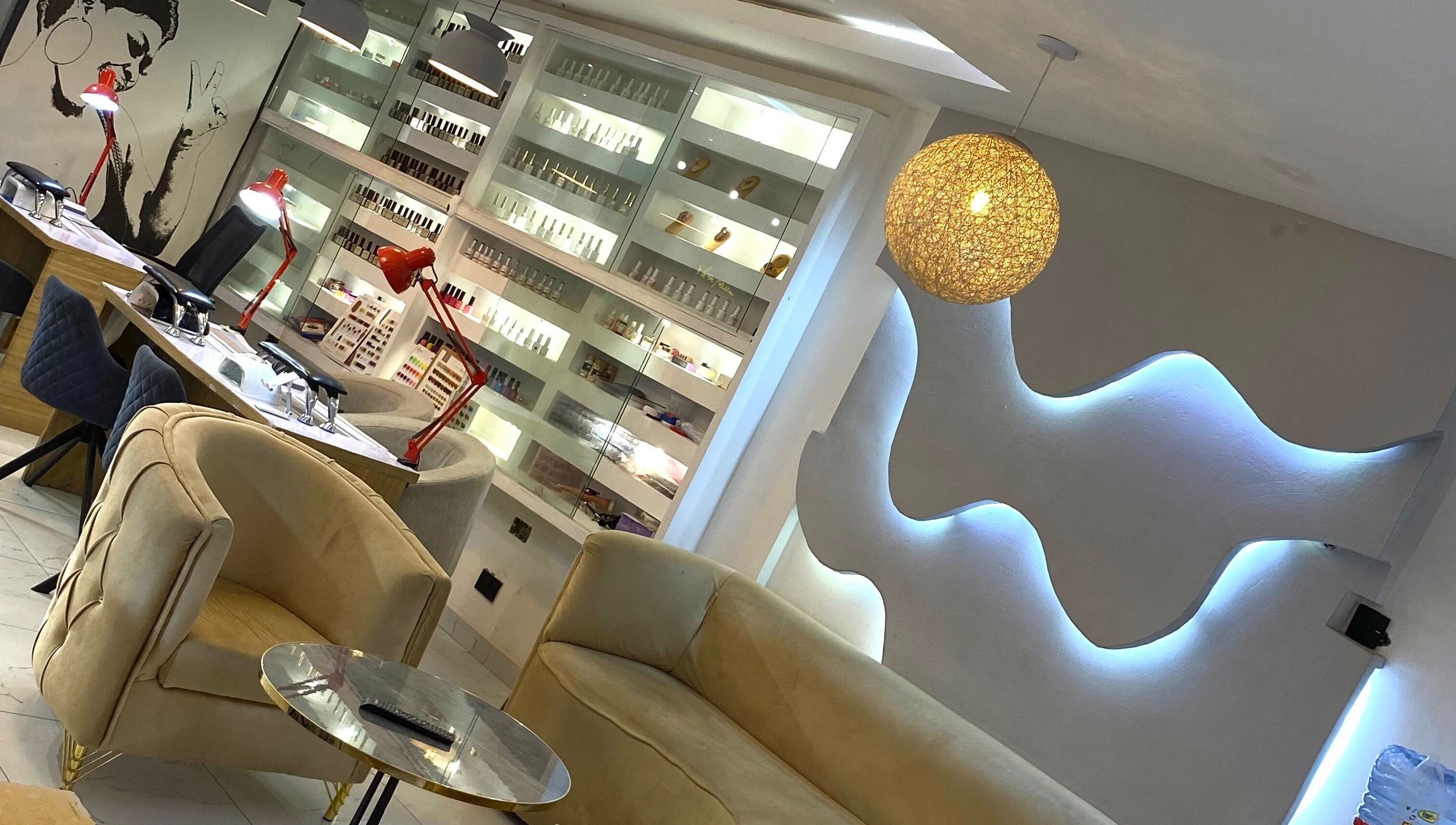 Modern interior of Everything Nails & Spa in Accra, showcasing chic seating and elegant lighting.
