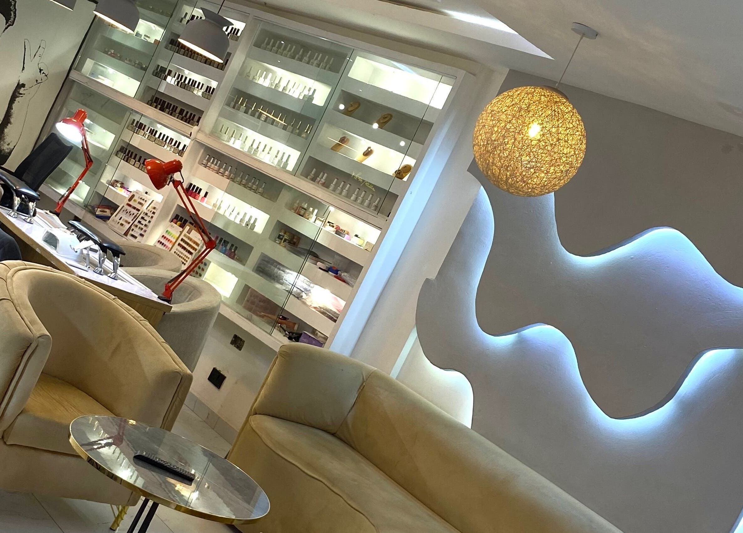 Modern interior of Everything Nails & Spa in Accra, showcasing chic seating and elegant lighting.