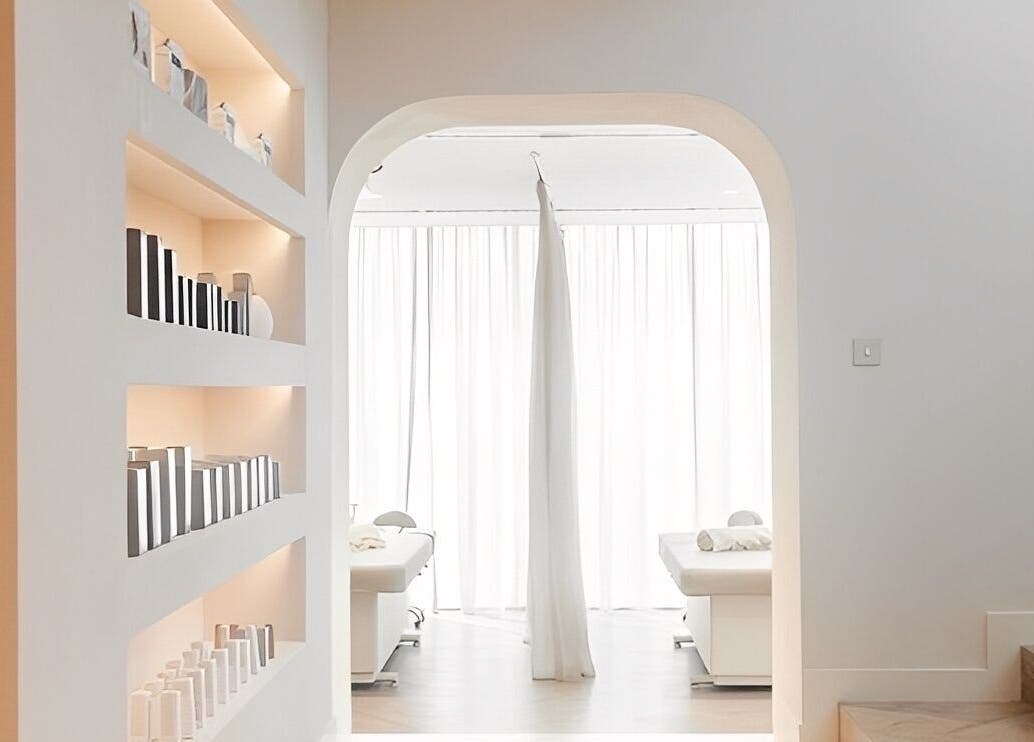 Calm, minimalist treatment room at BaharBrows in Dubai, Dubai, AE with light-filled space and sleek shelves.