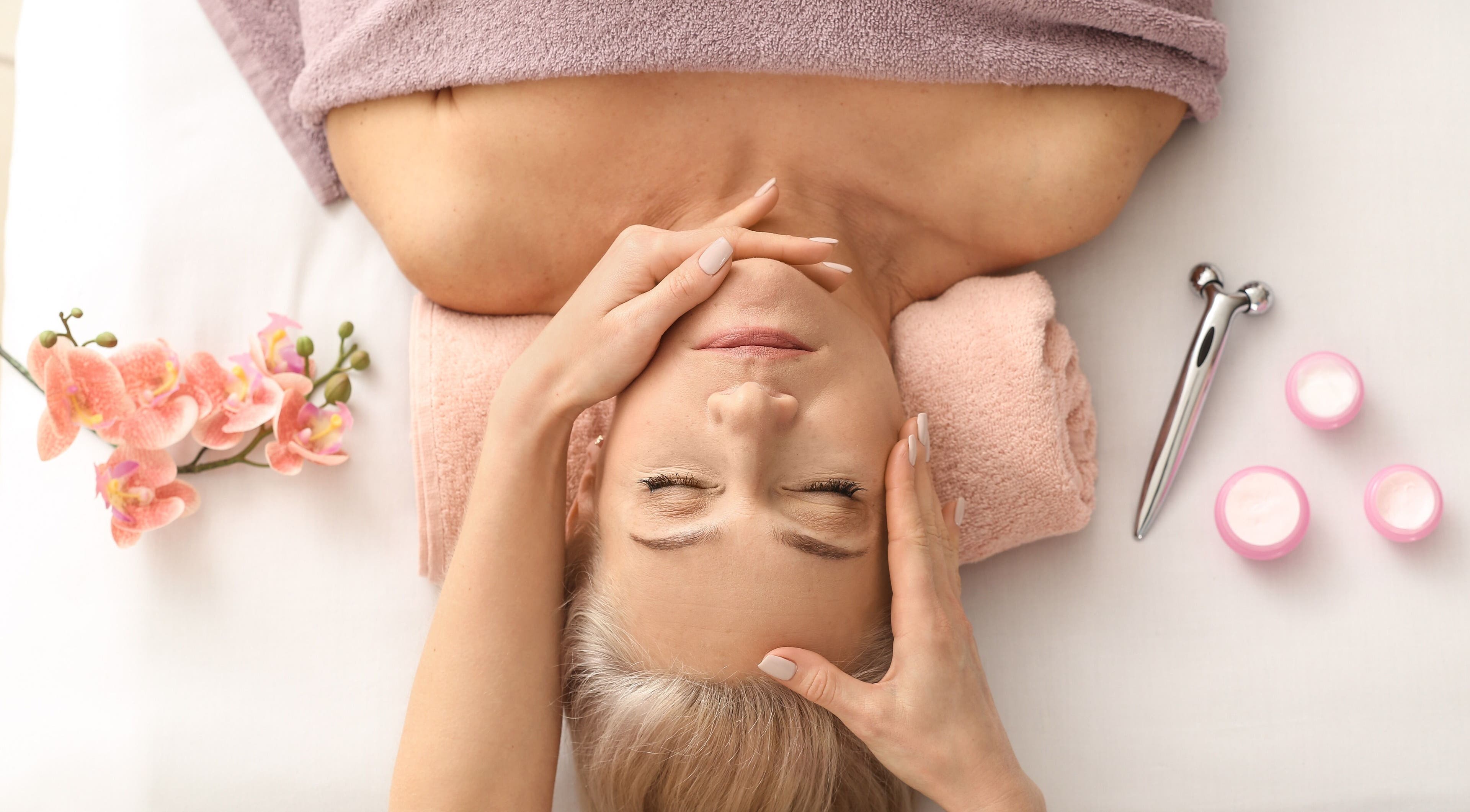 Relaxing facial massage at Wellbeing Beauty & Skin Topsham, Topsham, England, GB with flowers and skincare tools.
