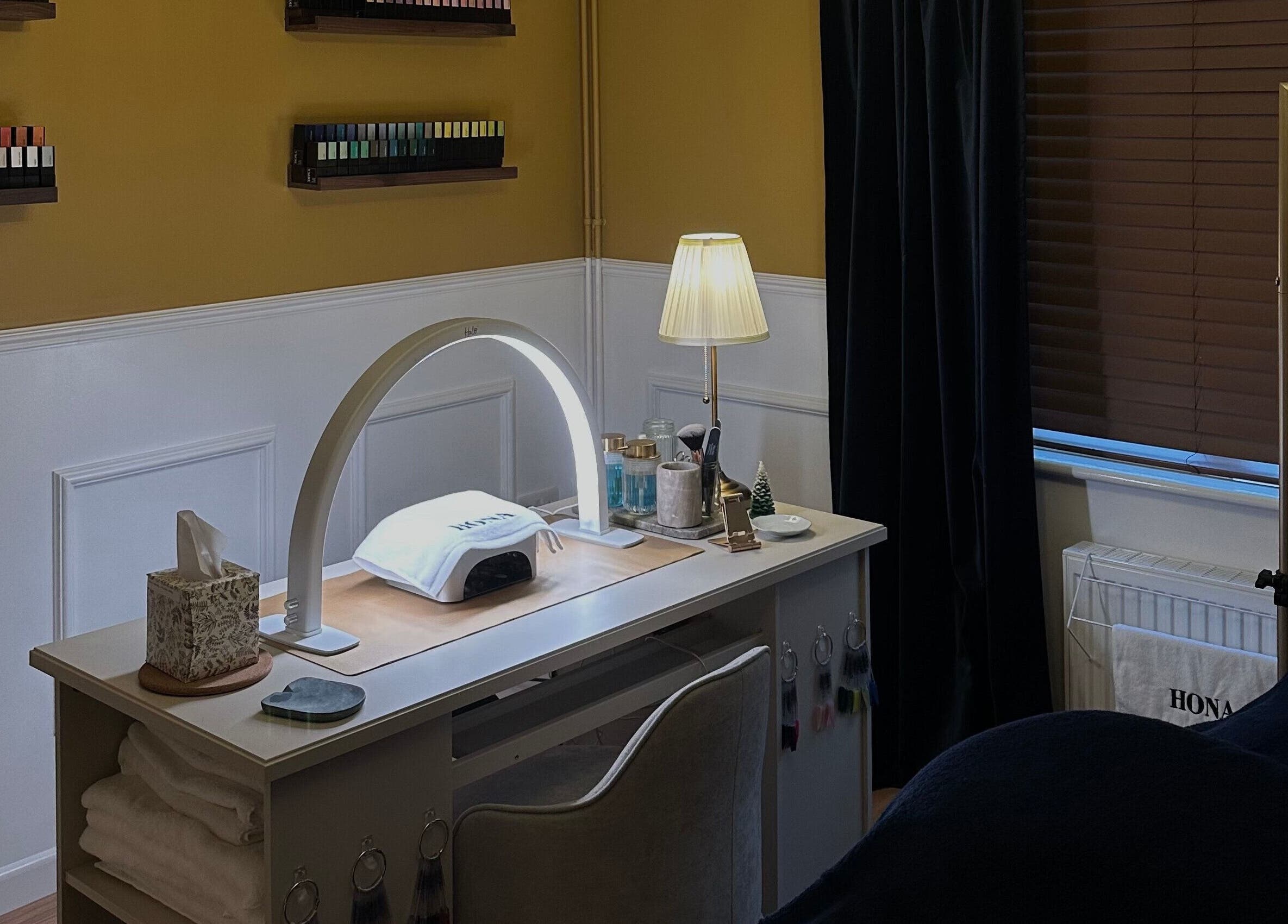 Modern nail station at Wellbeing Beauty & Skin Topsham in Exeter, England, GB, featuring cozy lighting and tools.