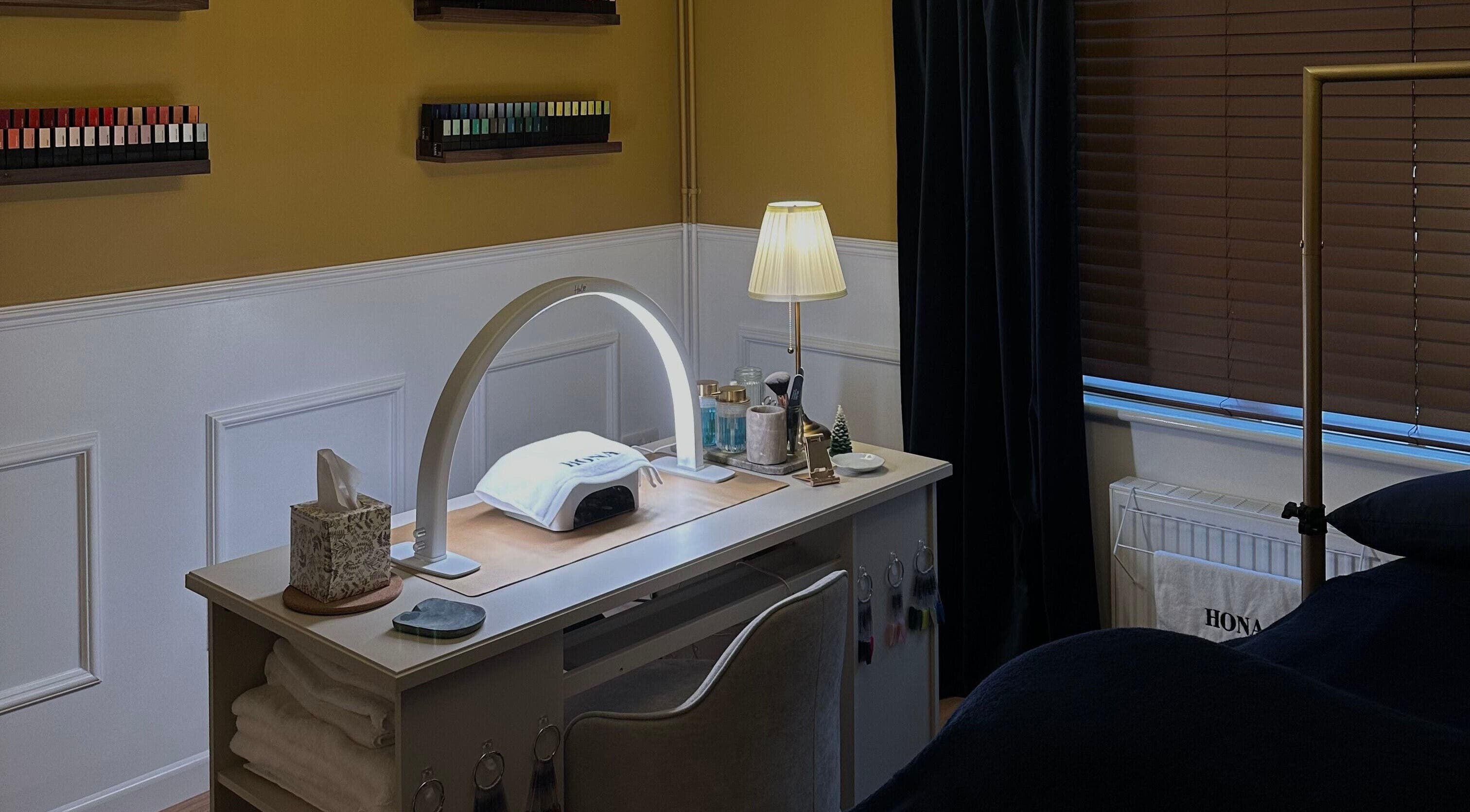 Nail station setup at Wellbeing Beauty & Skin Topsham in Exeter, England, GB, featuring manicure tools and cozy ambiance.