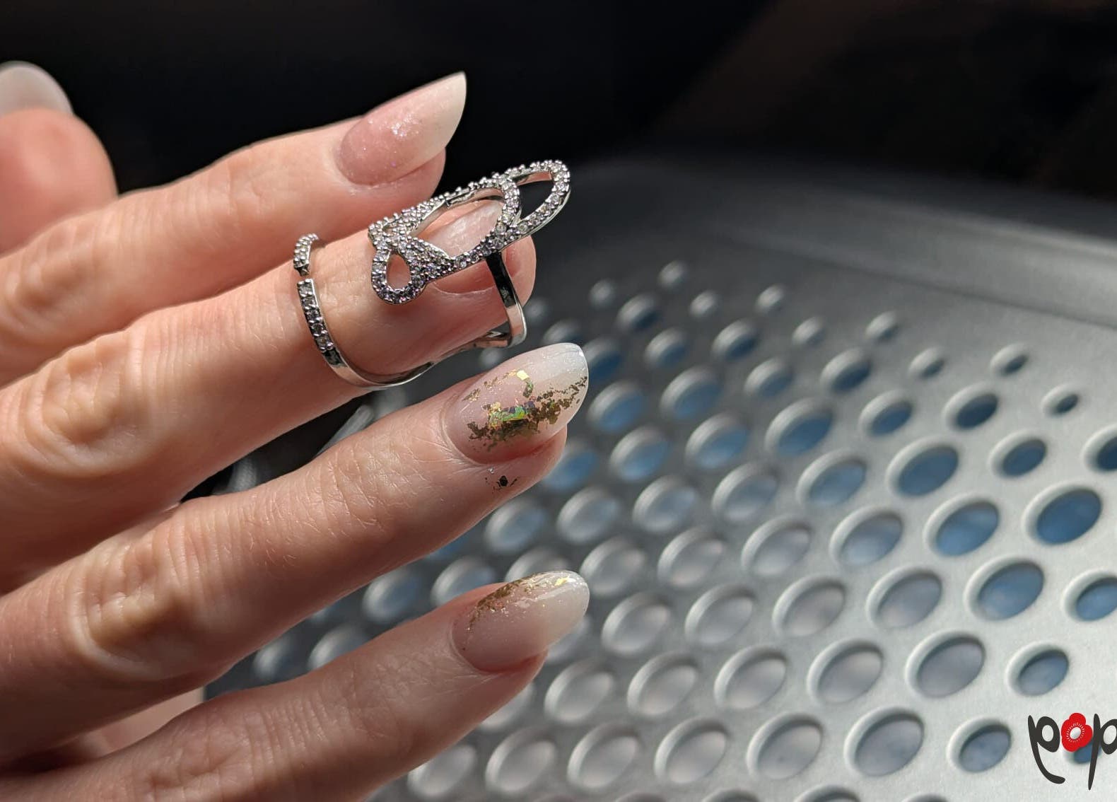 Design ongles élégant chez Poppynails, Saint Yvi, FR, avec bagues scintillantes.