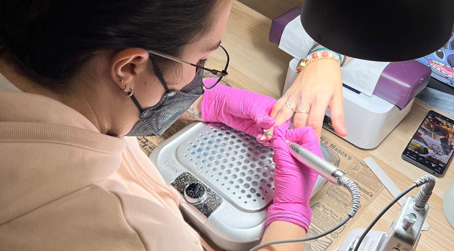 Technicienne effectuant une manucure chez Poppynails, Saint-yvi, Bretagne, FR.