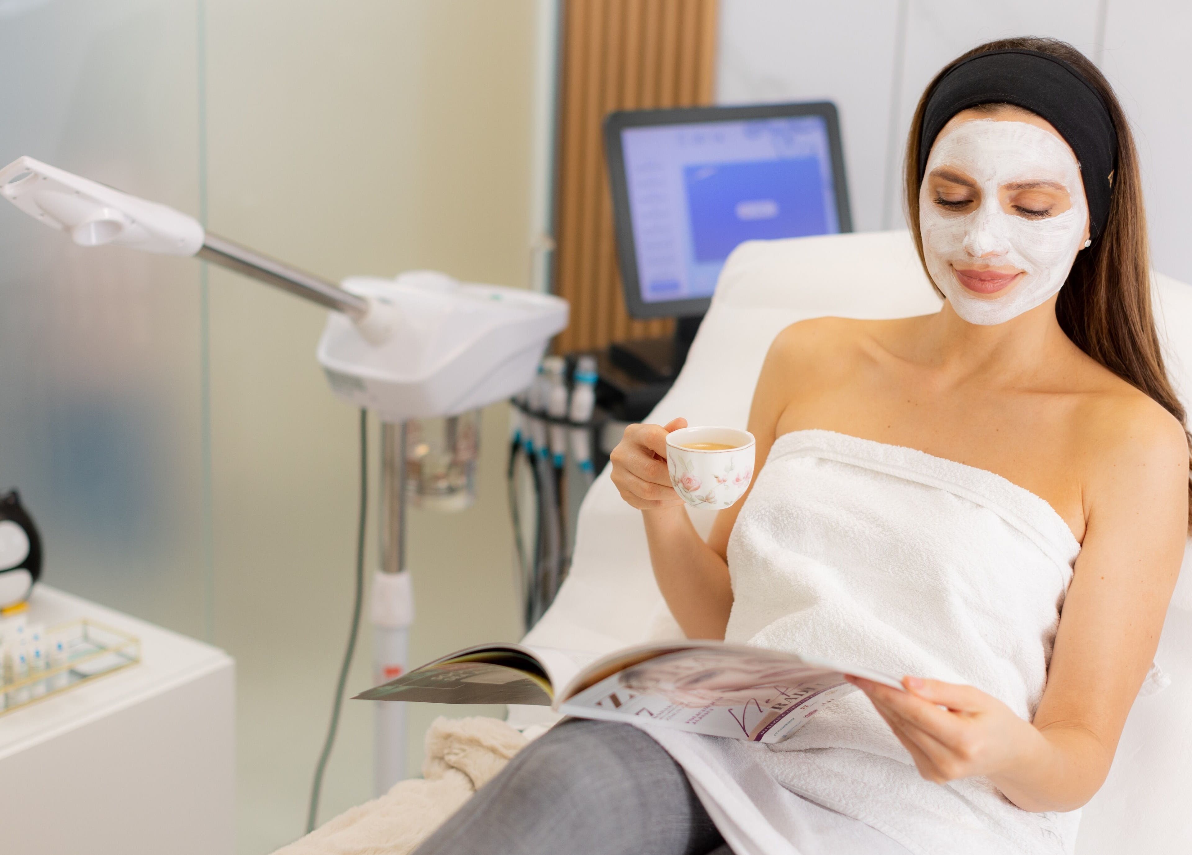 Client enjoys a facial treatment at Dermavie Clinique in Novi Sad, Vojvodina, RS, with a face mask and tea.
