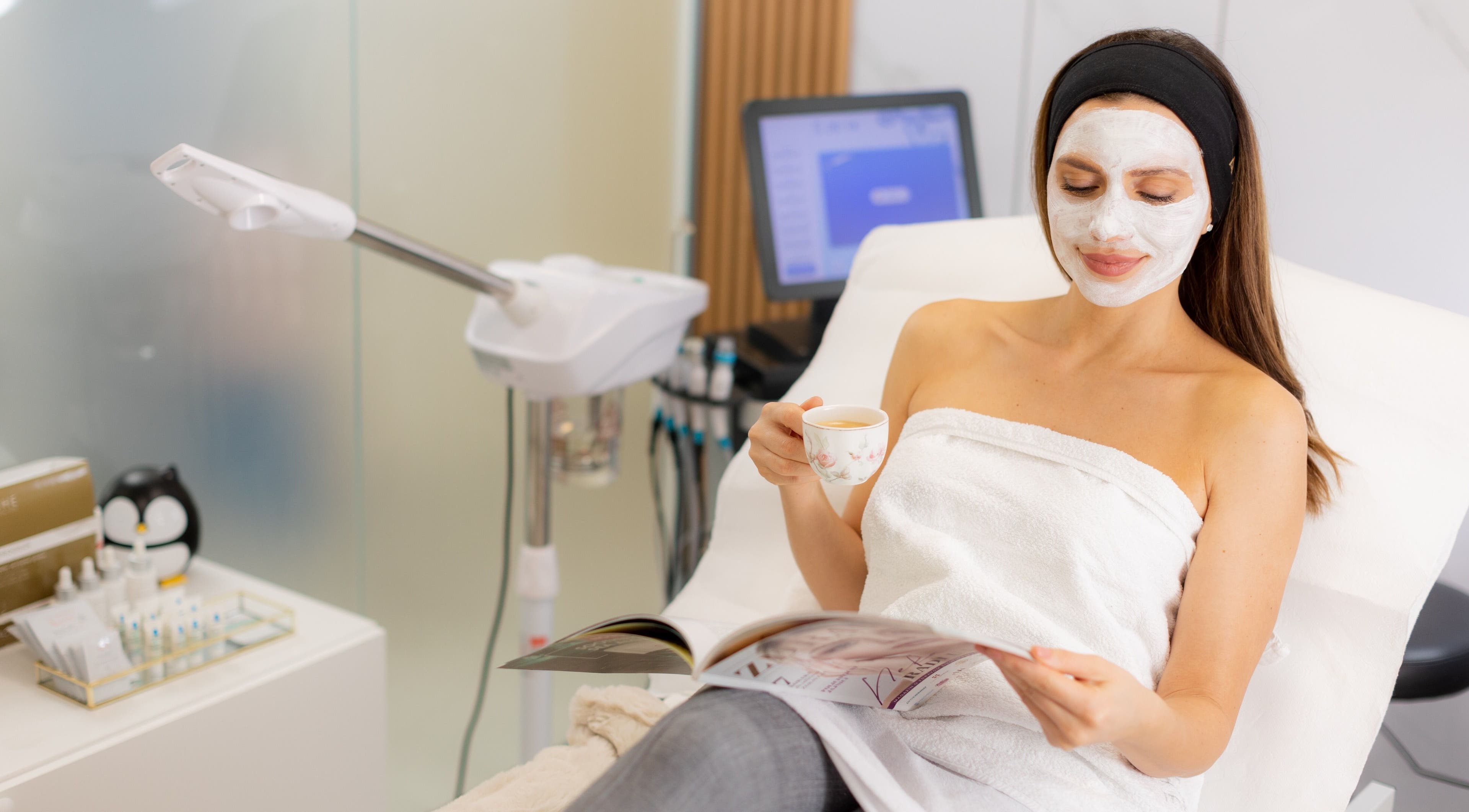 Client enjoys a facial treatment at Dermavie Clinique in Novi Sad, Vojvodina, RS, with a face mask and tea.