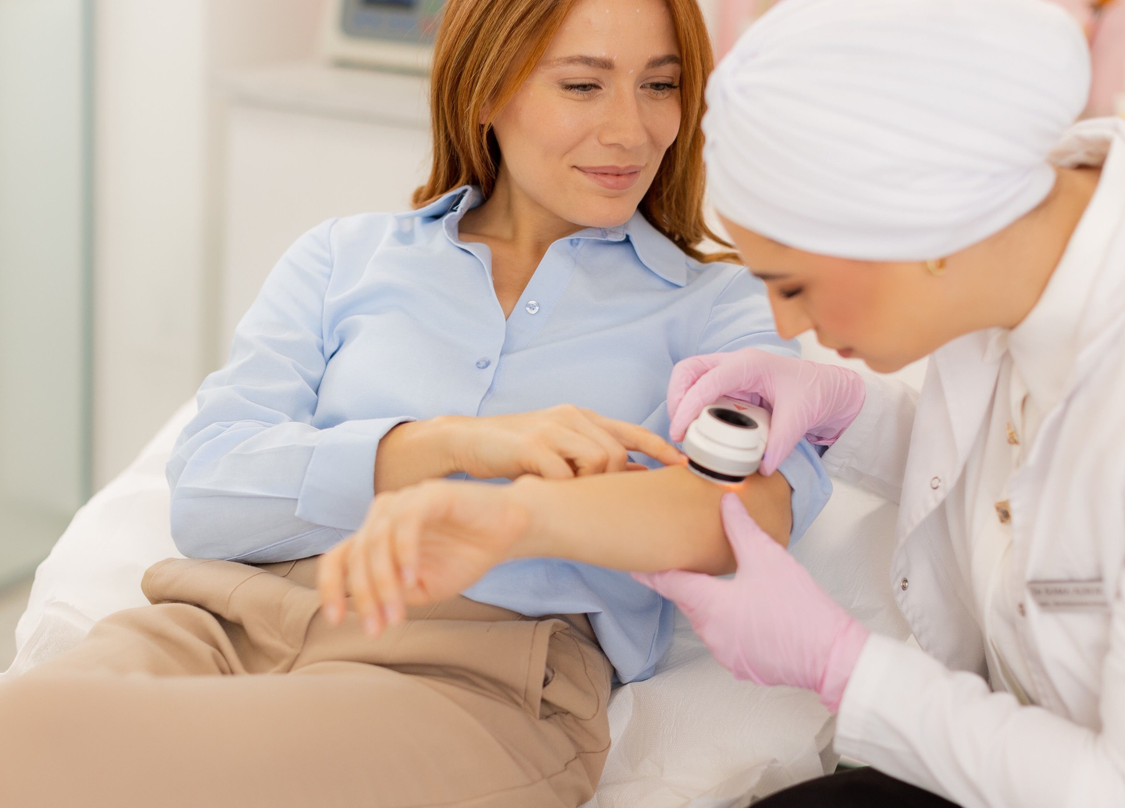 Dermatologist examines patient's arm at Dermavie Clinique, Novi Sad, Vojvodina, RS for a skincare consultation.