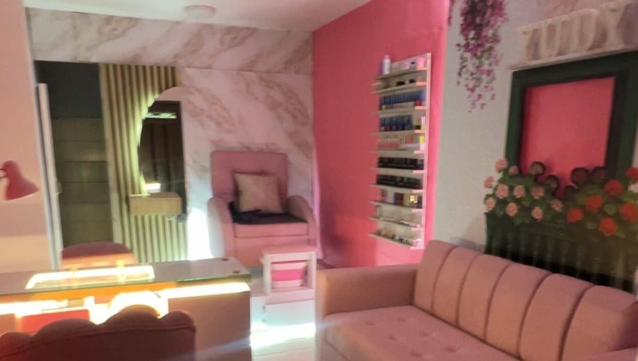 Cozy interior of Yudy Nails Studio, Medellín, Antioquia, CO with plush pink seating and chic decor.