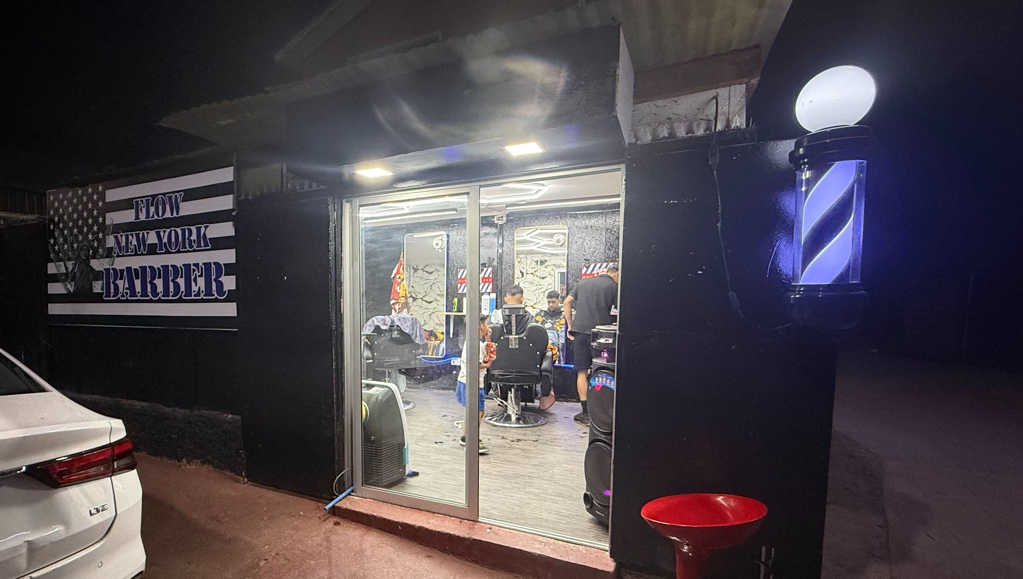 Flow newyork barber at night in Colina, Región Metropolitana, CL, warmly lit with barbers inside.