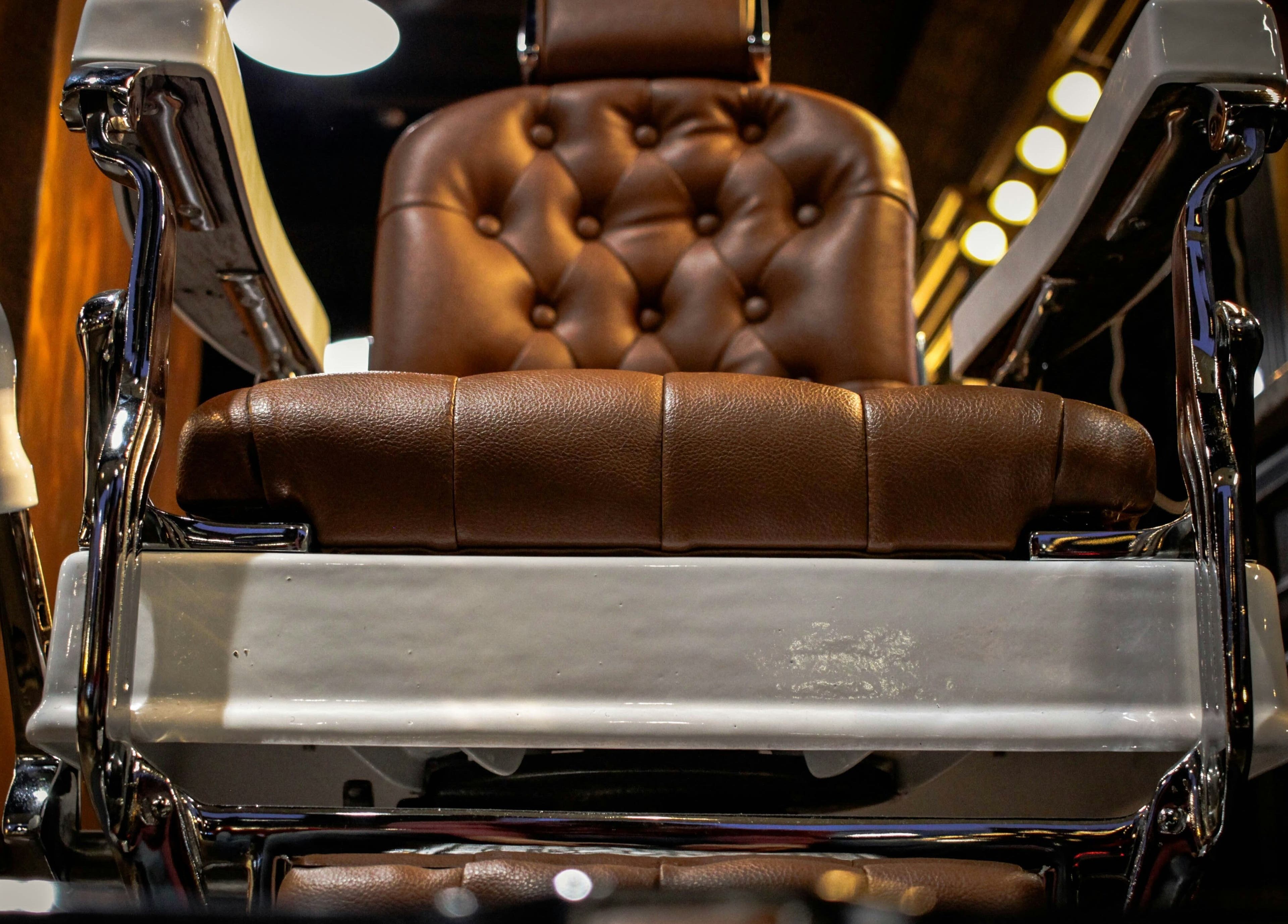 Silla de barbería clásica en Barberia Vikingos, Rosario, Santa Fe, AR, destacando cuero marrón lujoso.