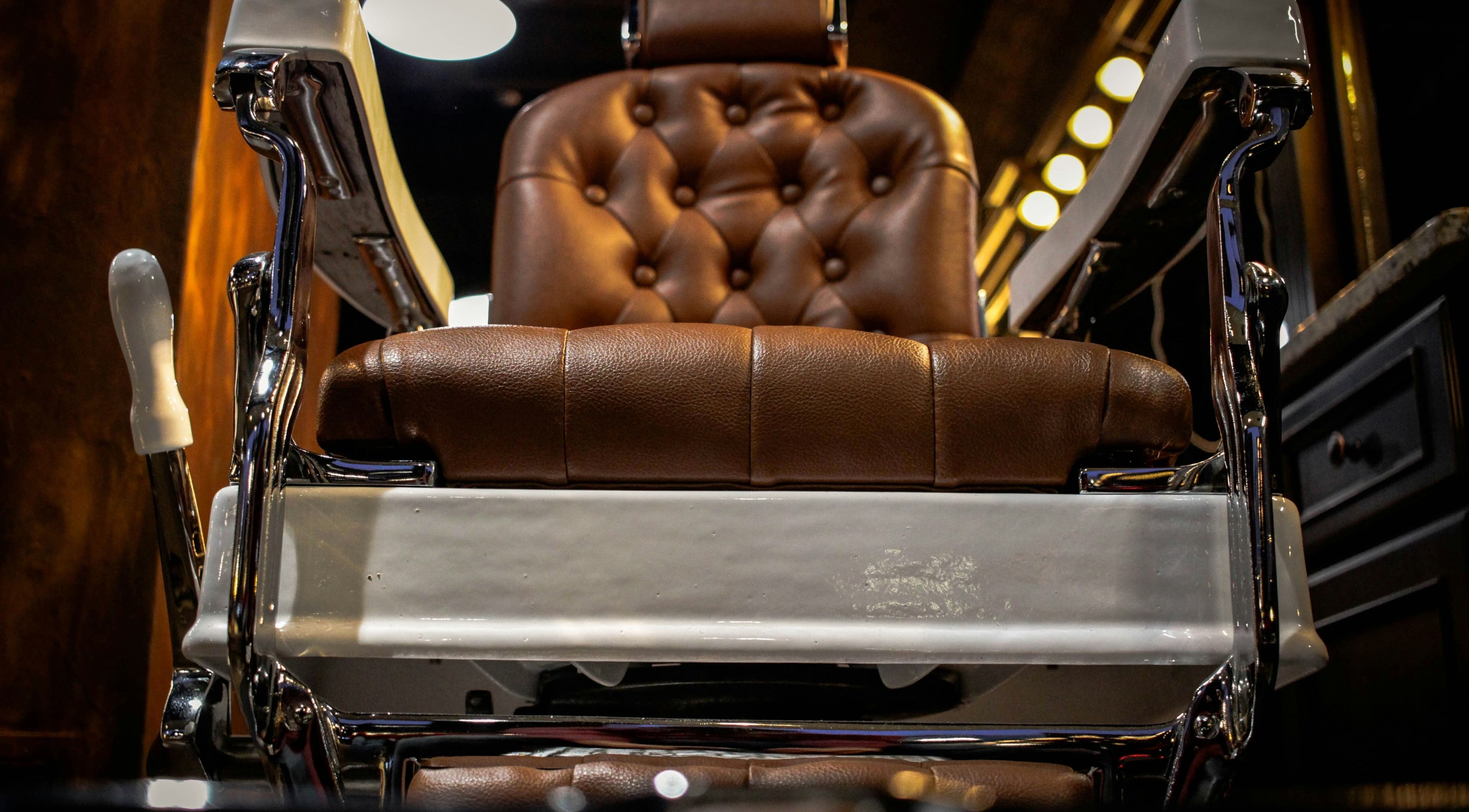 Silla de barbería clásica en Barberia Vikingos, Rosario, Santa Fe, AR, destacando cuero marrón lujoso.