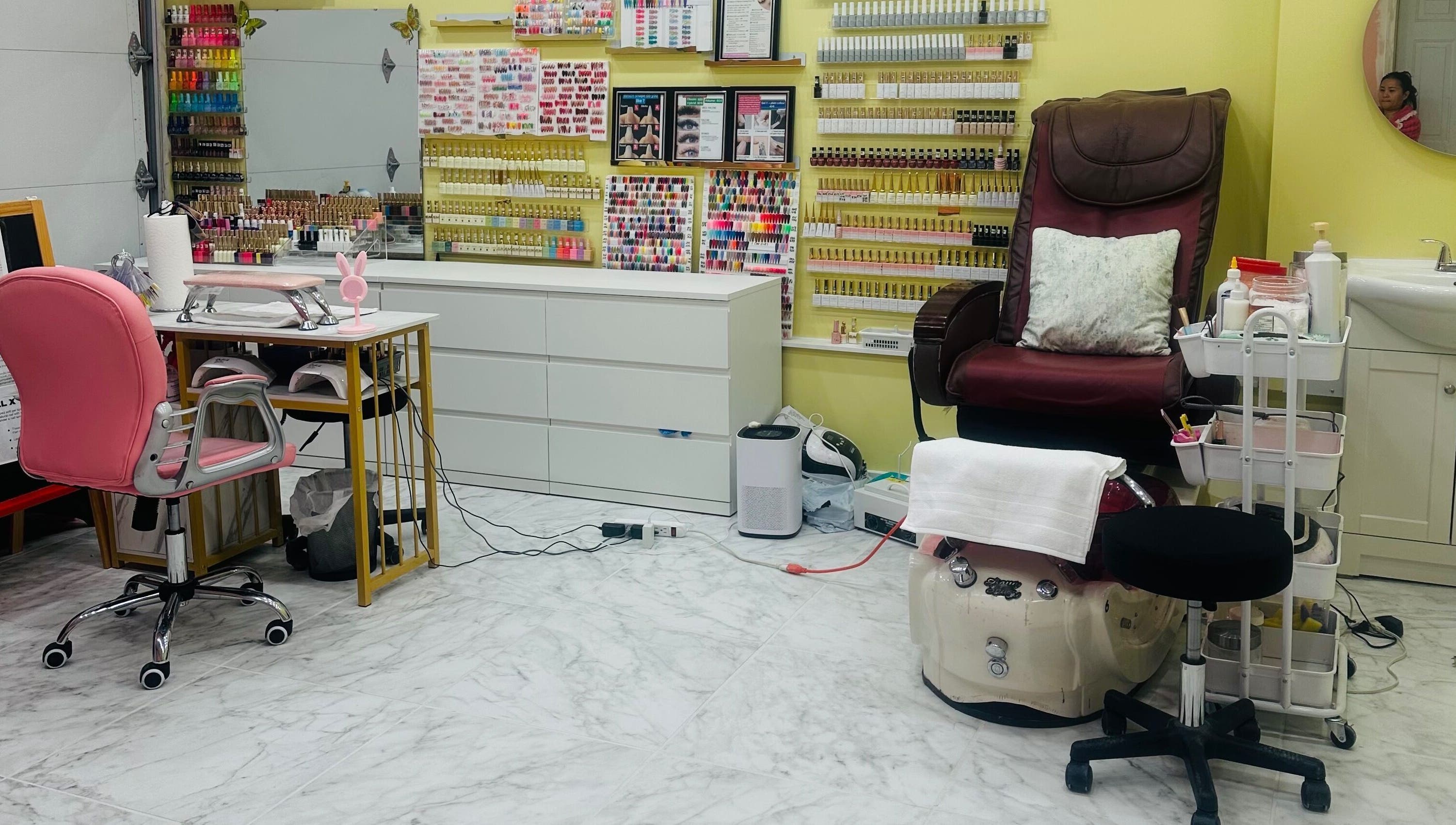 Chic nail studio at Nails By Hannah Le in Calgary, Alberta, CA, showcasing vibrant polish selection and cozy pedicure chair.