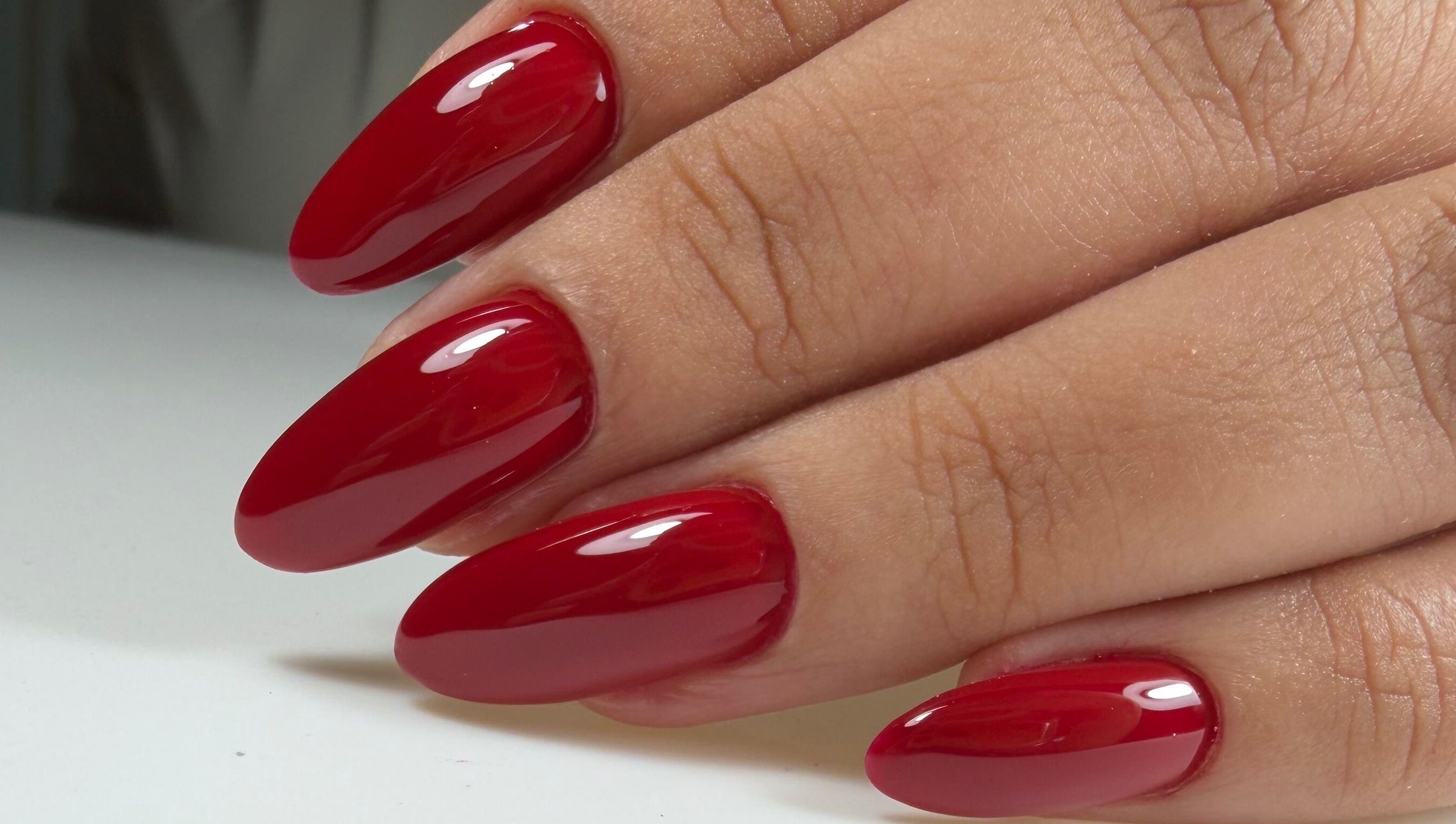 Glossy red manicure by Ana's Nails Studio, located in Paramaribo, Paramaribo, SR, showcasing elegant nail art.