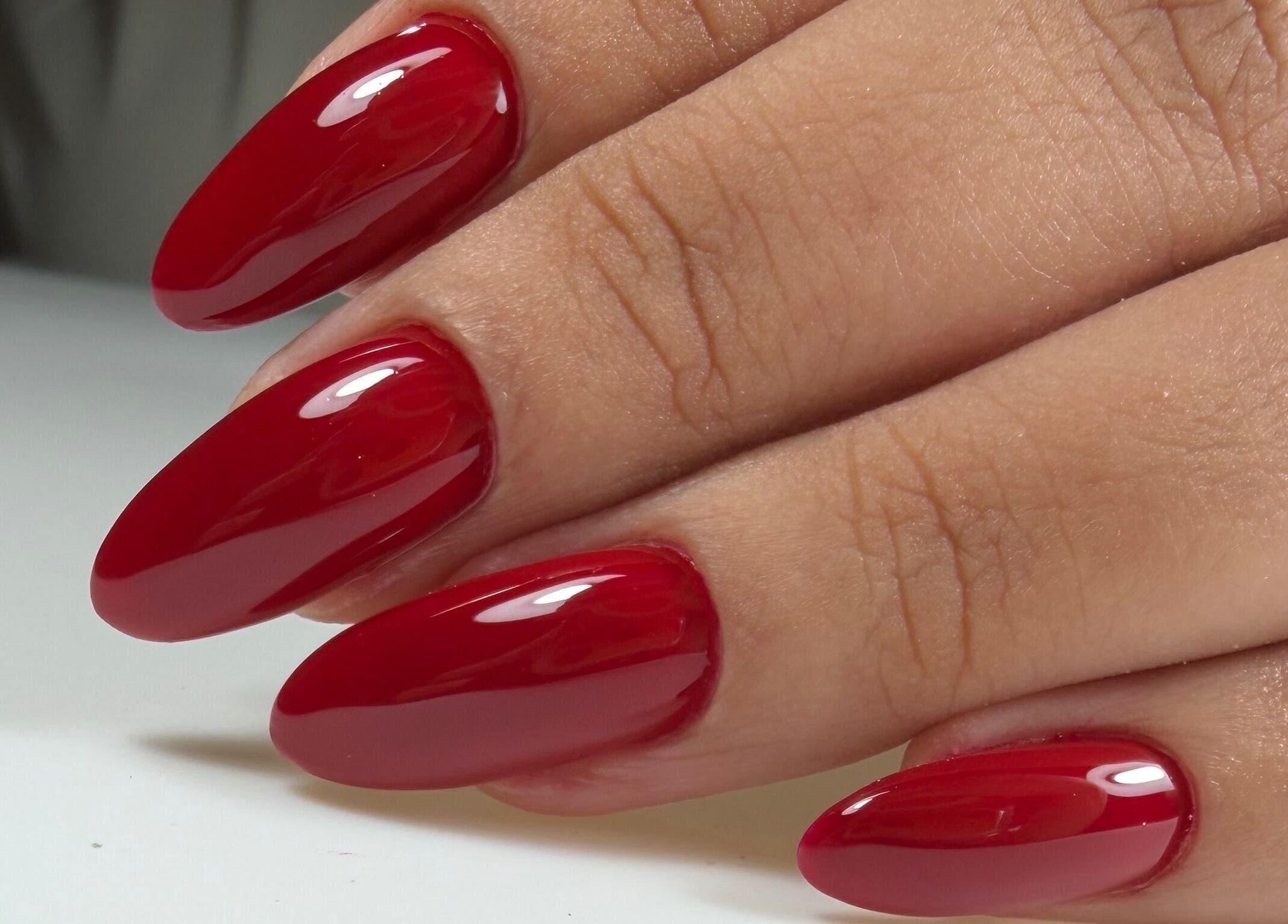 Glossy red manicure by Ana's Nails Studio, located in Paramaribo, Paramaribo, SR, showcasing elegant nail art.