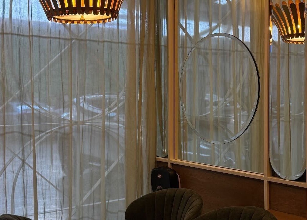 Chic seating area at Harlow, San Pedro Garza García, Nuevo León, MX with modern lighting and mirrors.