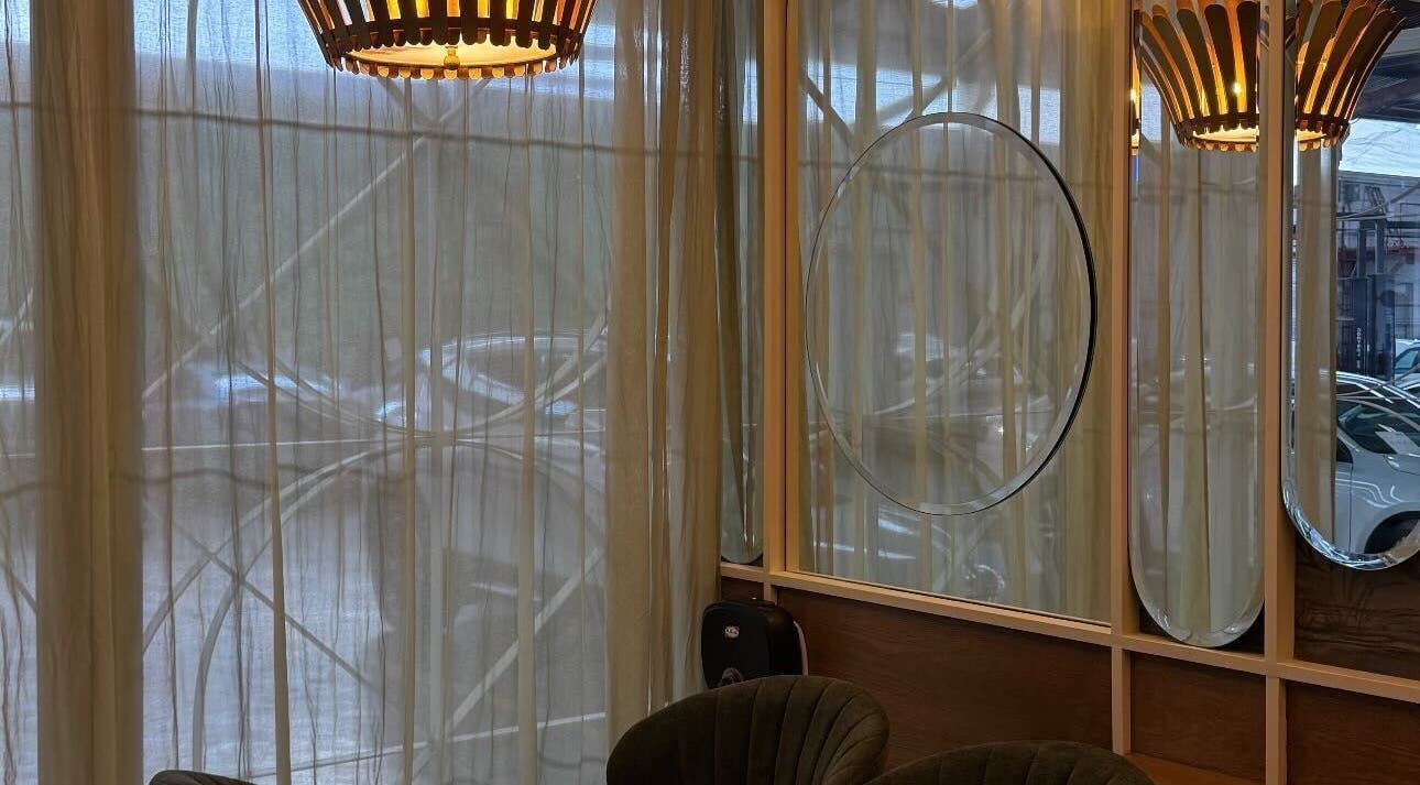 Chic seating area at Harlow, San Pedro Garza García, Nuevo León, MX with modern lighting and mirrors.