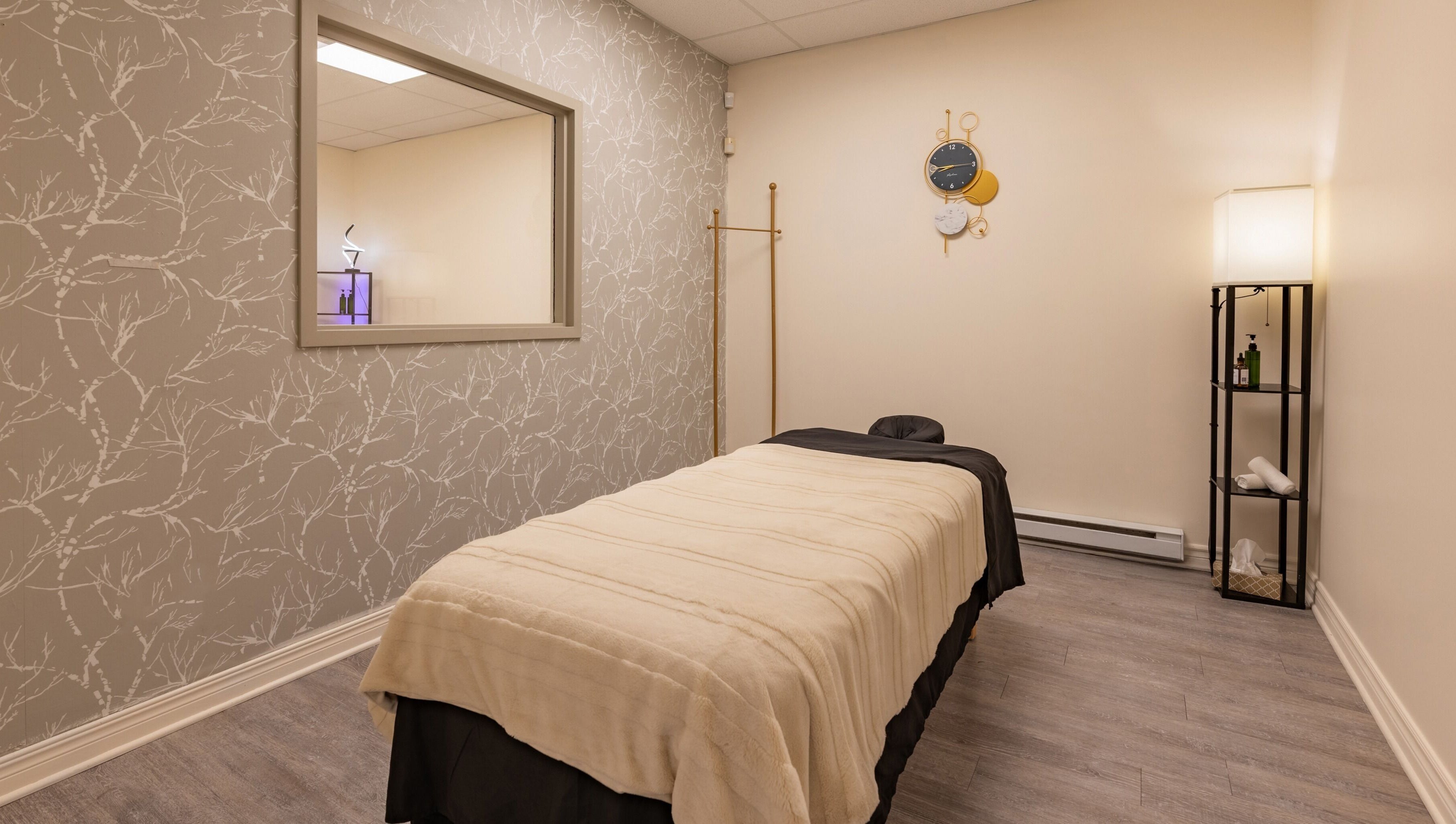 Relaxing massage room at Institut NewYou, Sainte-Anne-de-bellevue, Québec, CA with plush bed and elegant decor.