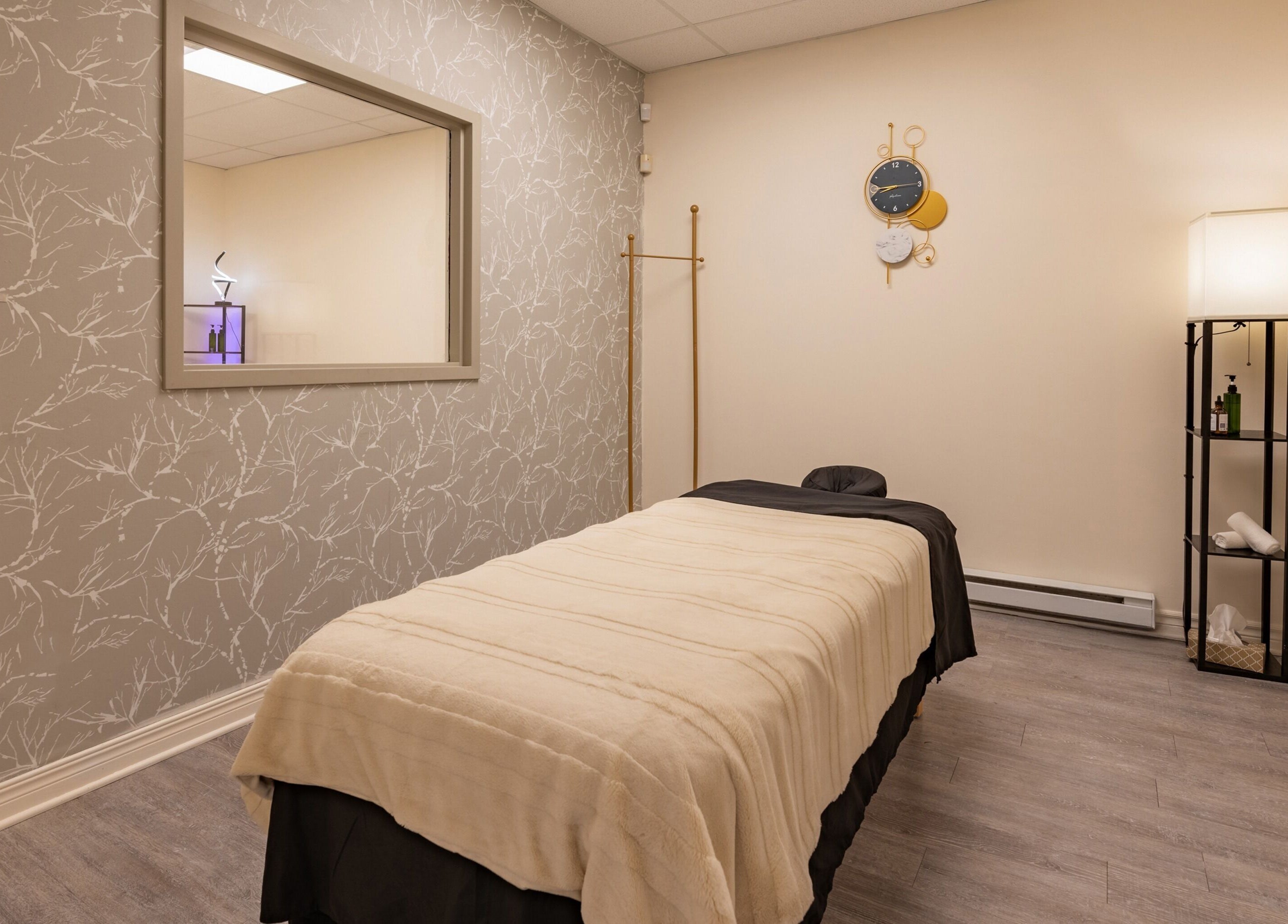 Relaxing massage room at Institut NewYou, Sainte-Anne-de-bellevue, Québec, CA with plush bed and elegant decor.