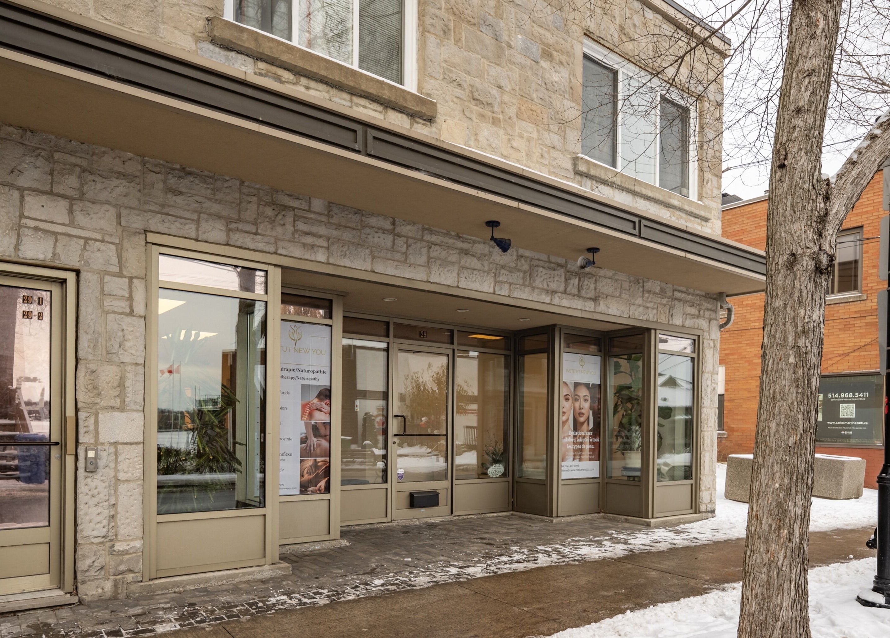 Front view of Institut NewYou in Sainte-Anne-de-Bellevue, Québec, showcasing elegant stone facade and glass windows.