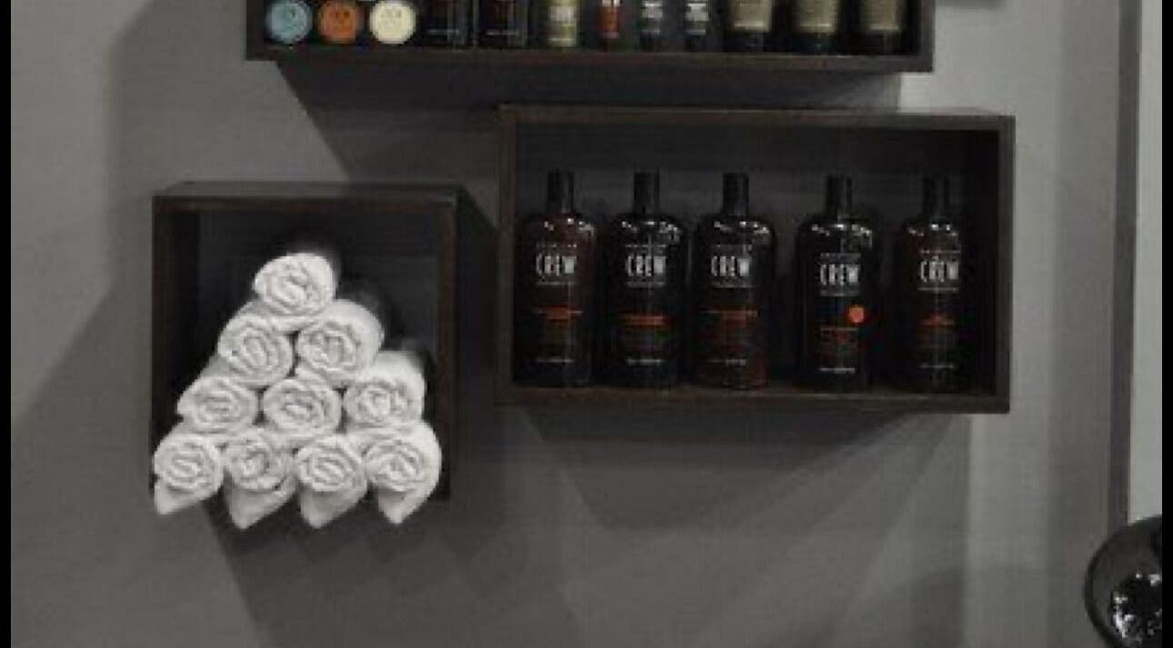 Elegant product display at THE BARBER ONE in San Andrés Cholula, Puebla, MX featuring hair products and towels.