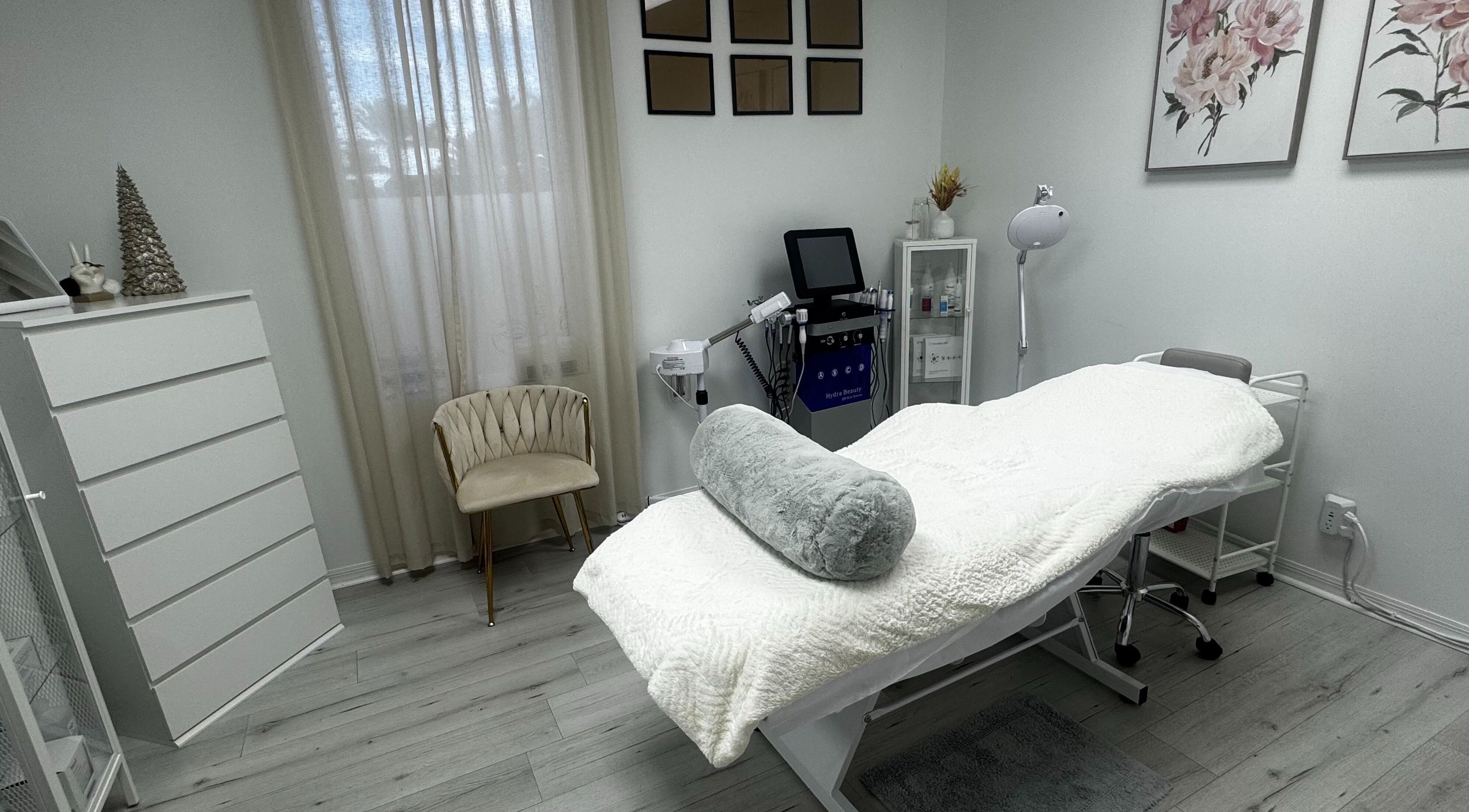 Tanova Aesthetics treatment room in Hallandale Beach, Florida, US with a plush bed and modern decor.