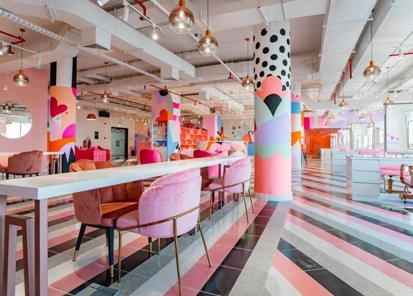 Bright, colorful interior of Pretty Wow, Dubai, Dubai, AE, featuring pink chairs and artistic decor.