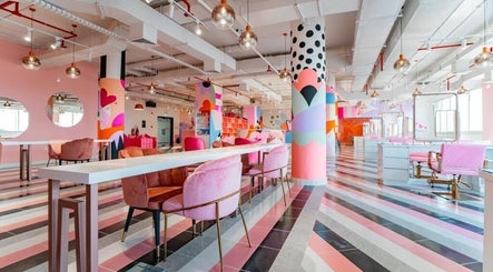 Bright, colorful interior of Pretty Wow, Dubai, Dubai, AE, featuring pink chairs and artistic decor.