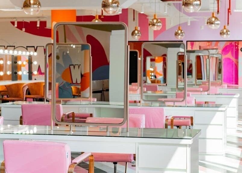 Stylish beauty salon interior at Pretty Wow, Dubai, Dubai, AE, featuring pink chairs and colorful decor.