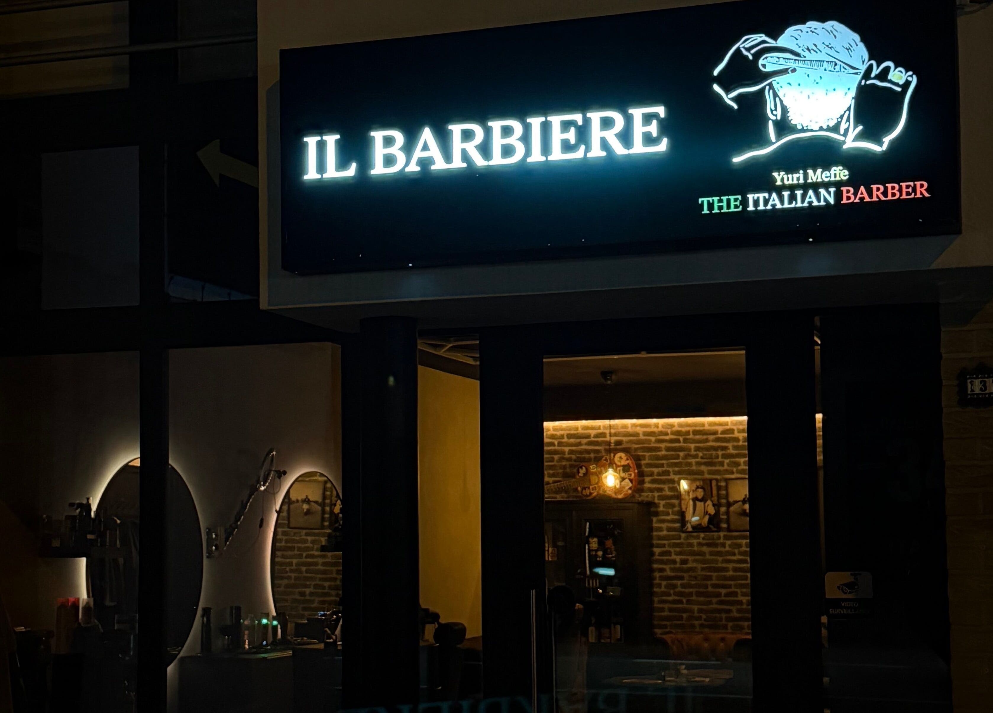 Buitenaanzicht van The Italian Barber in Hasselt, Vlaanderen, BE met verlicht bord.