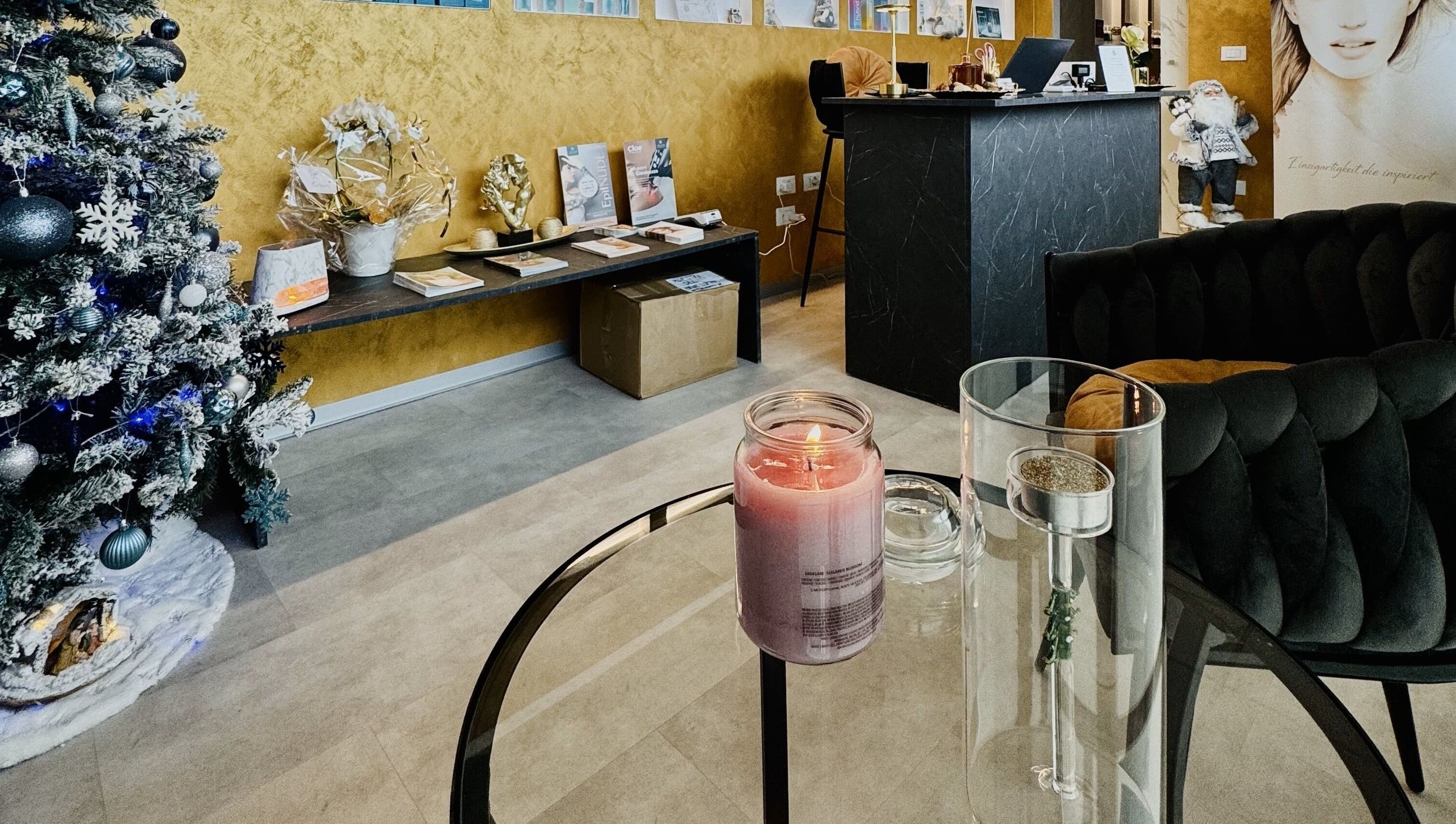 Interno di Kyrobeautysrl a Udine, con decorazioni natalizie e candela profumata sul tavolo.
