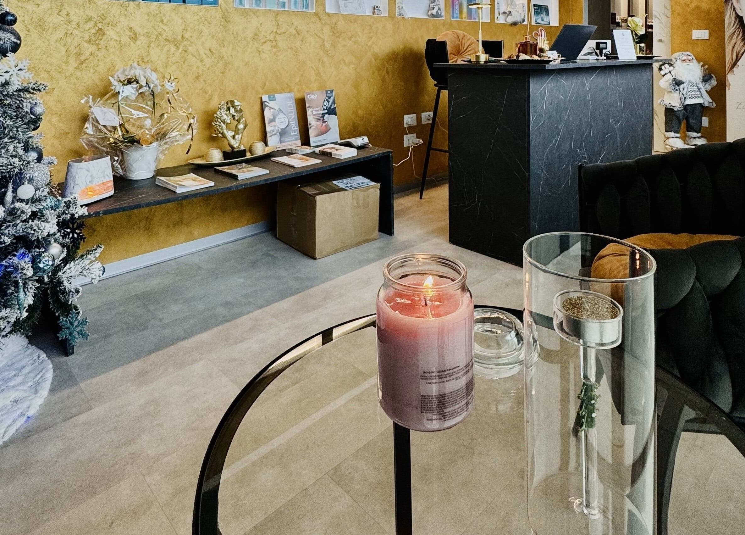 Interno di Kyrobeautysrl a Udine, con decorazioni natalizie e candela profumata sul tavolo.