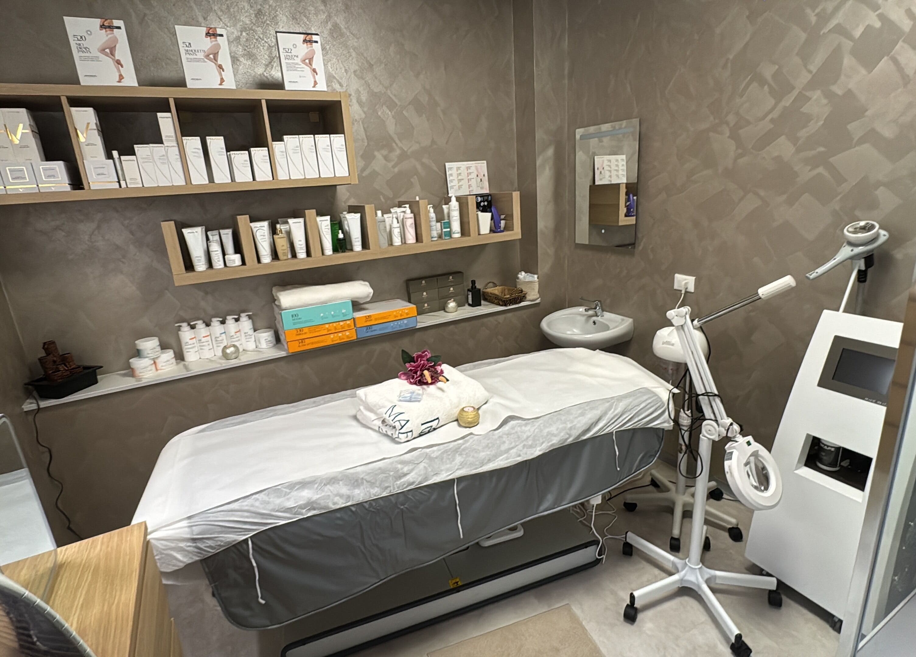 Sala trattamento presso Kyrobeautysrl a Udine, Friuli-venezia Giulia, IT con prodotti benessere e lettino.