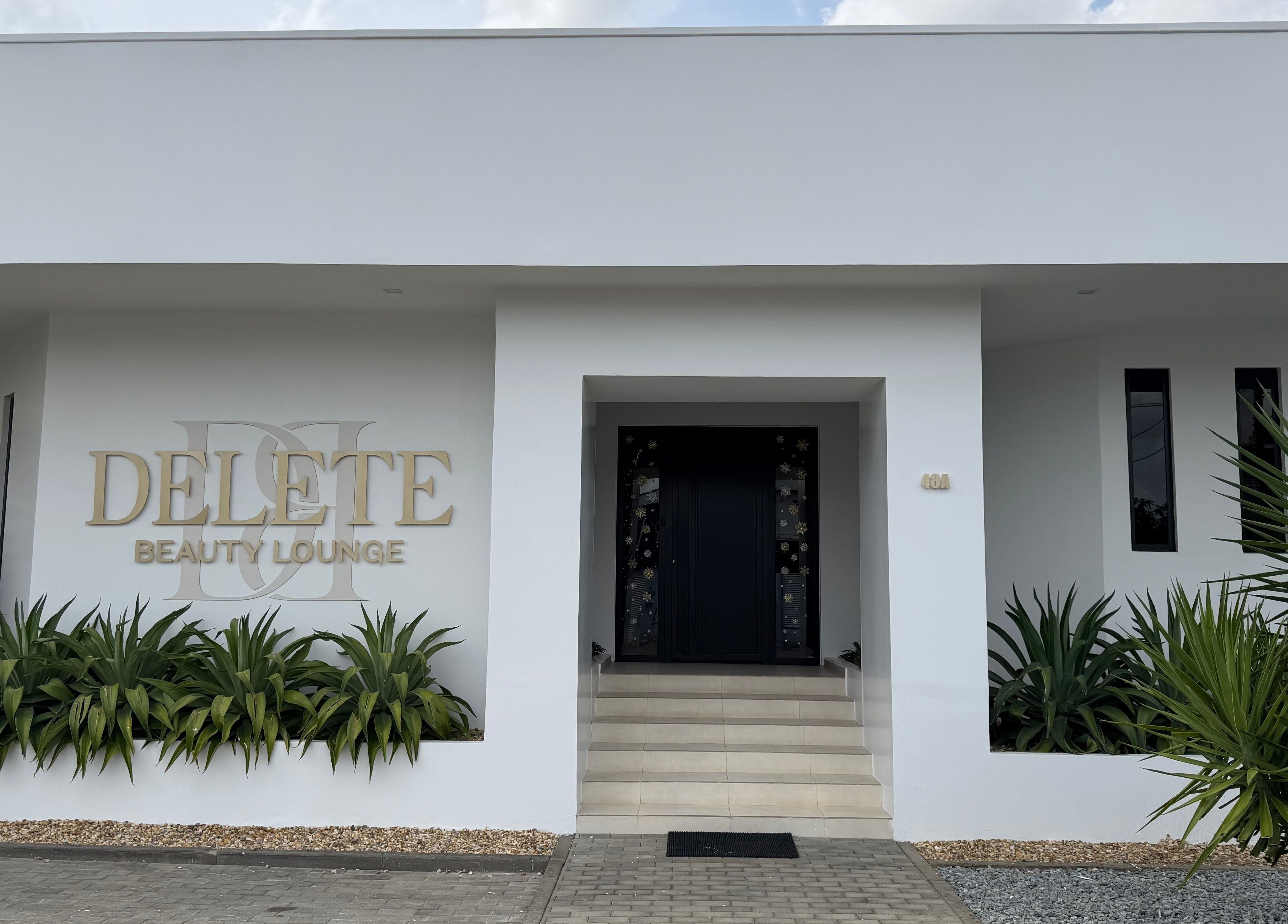 Elegant exterior of Delete Beauty Lounge in Paramaribo, Paramaribo, SR with lush greenery.