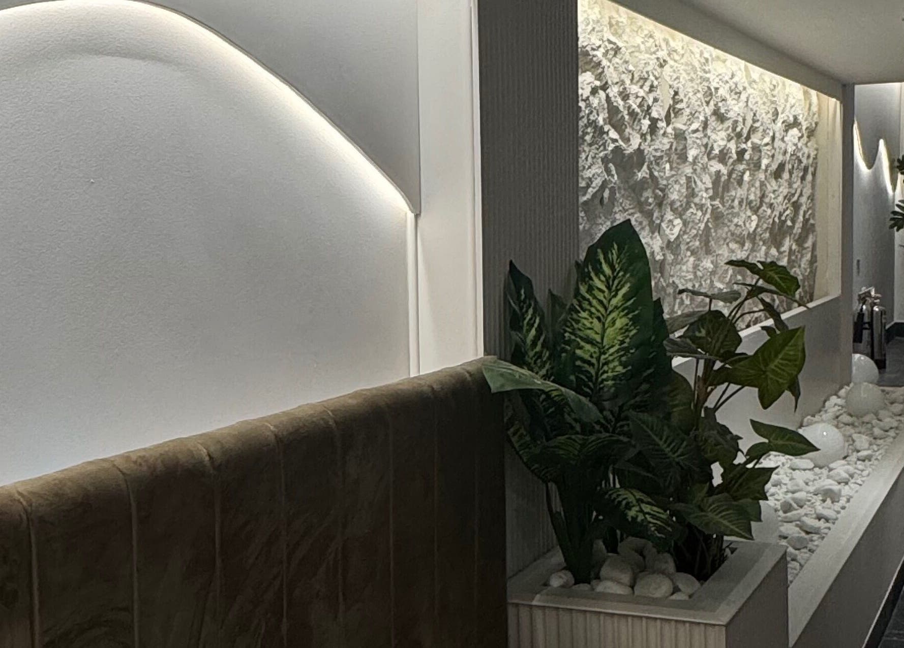 Tranquil modern interior at By Amarni Tian, London, England, GB, featuring soft lighting and lush plants.