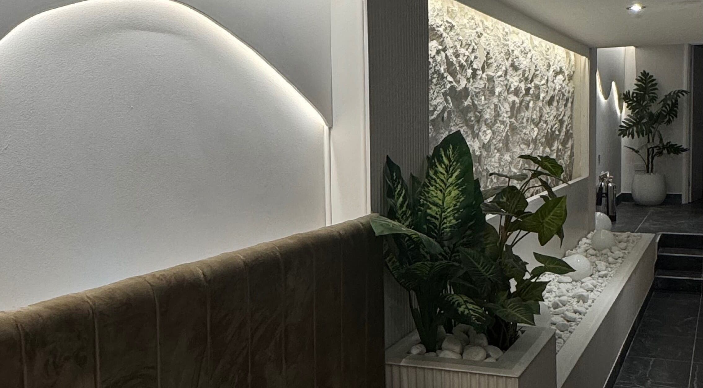 Tranquil modern interior at By Amarni Tian, London, England, GB, featuring soft lighting and lush plants.