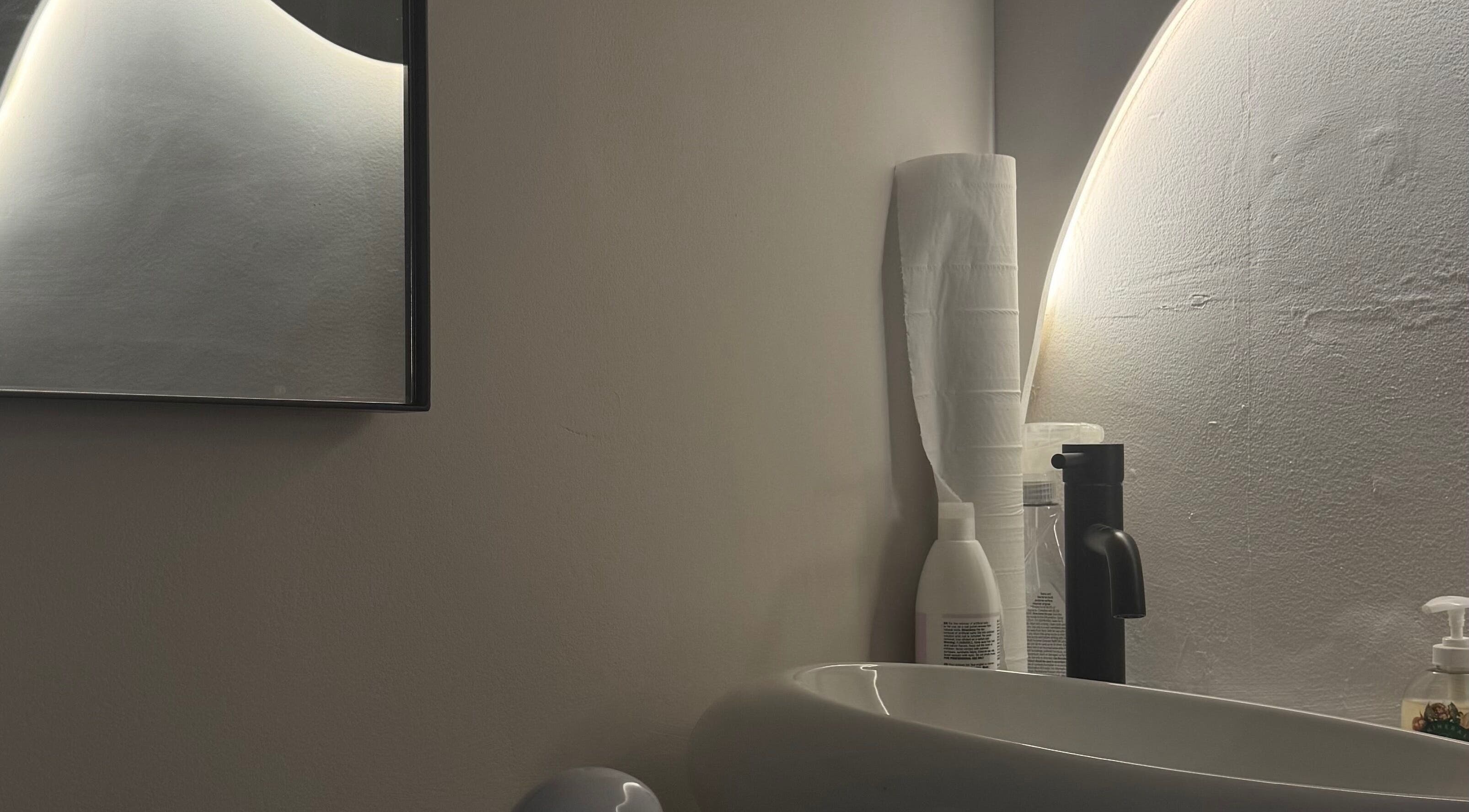 Modern vanity mirror and sink at By Amarni Tian, London, England, GB. Perfect for a luxurious beauty experience.