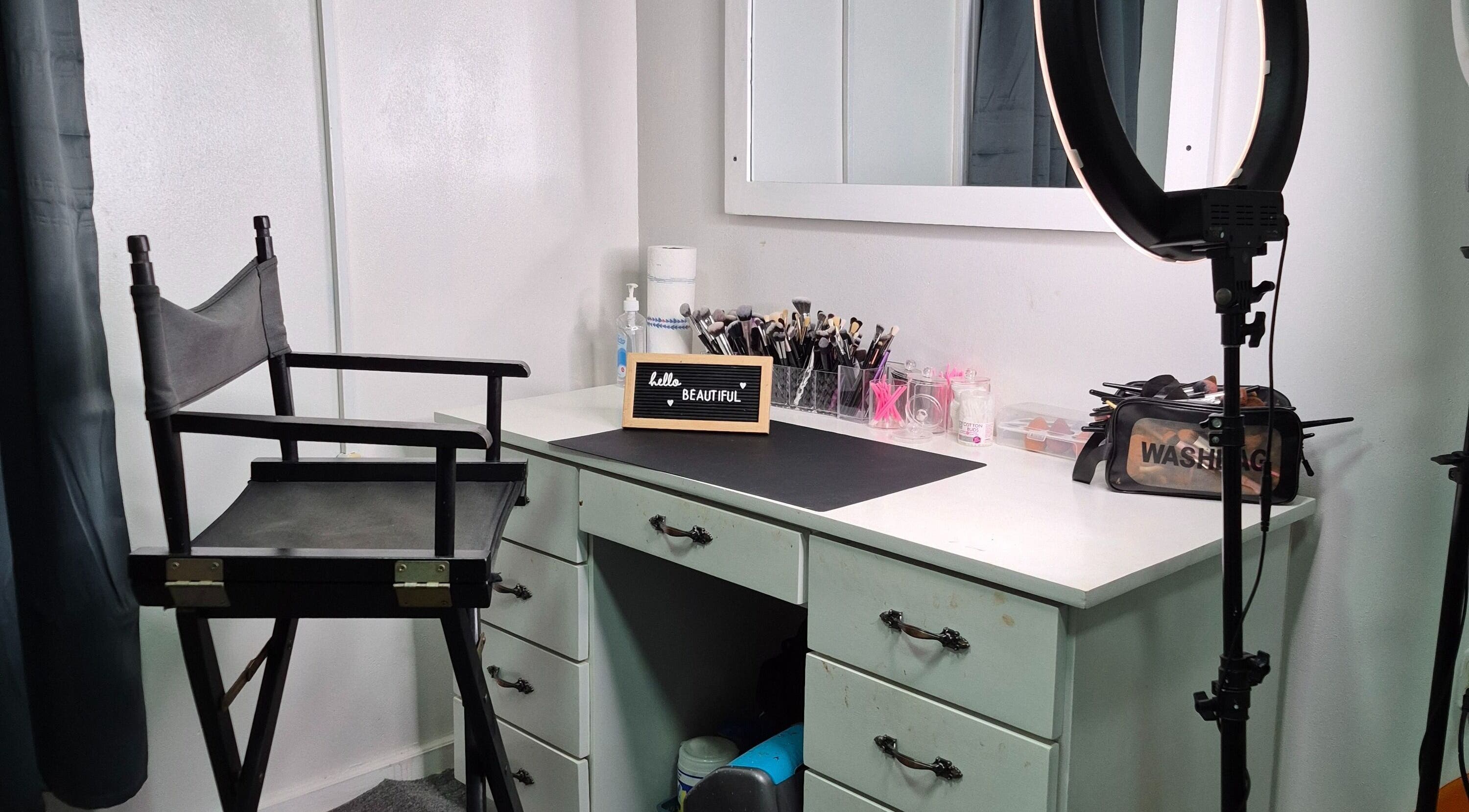 Chic makeup station at Exotic Beats Makeup Studio, Georgetown, GY, with chair, ring light, and cosmetics.