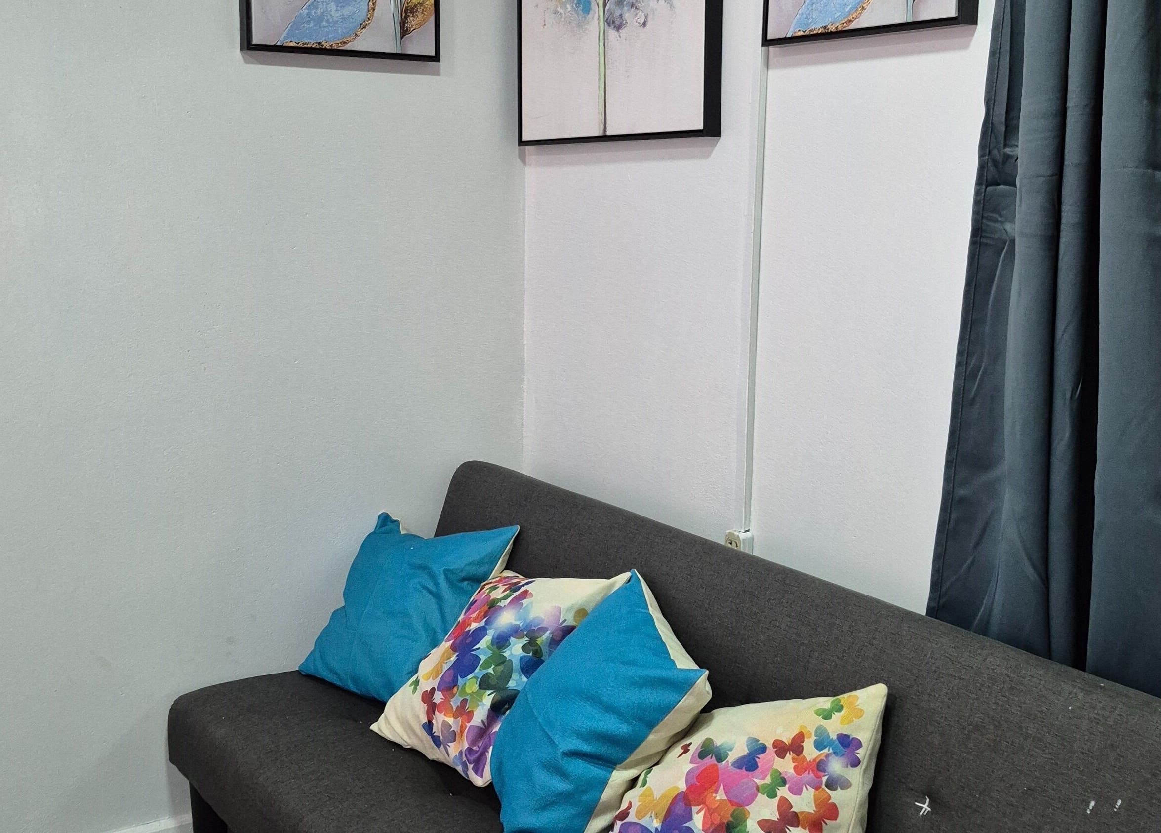 Stylish seating at Exotic Beats Makeup Studio in Georgetown, GY with colorful cushions and framed art.