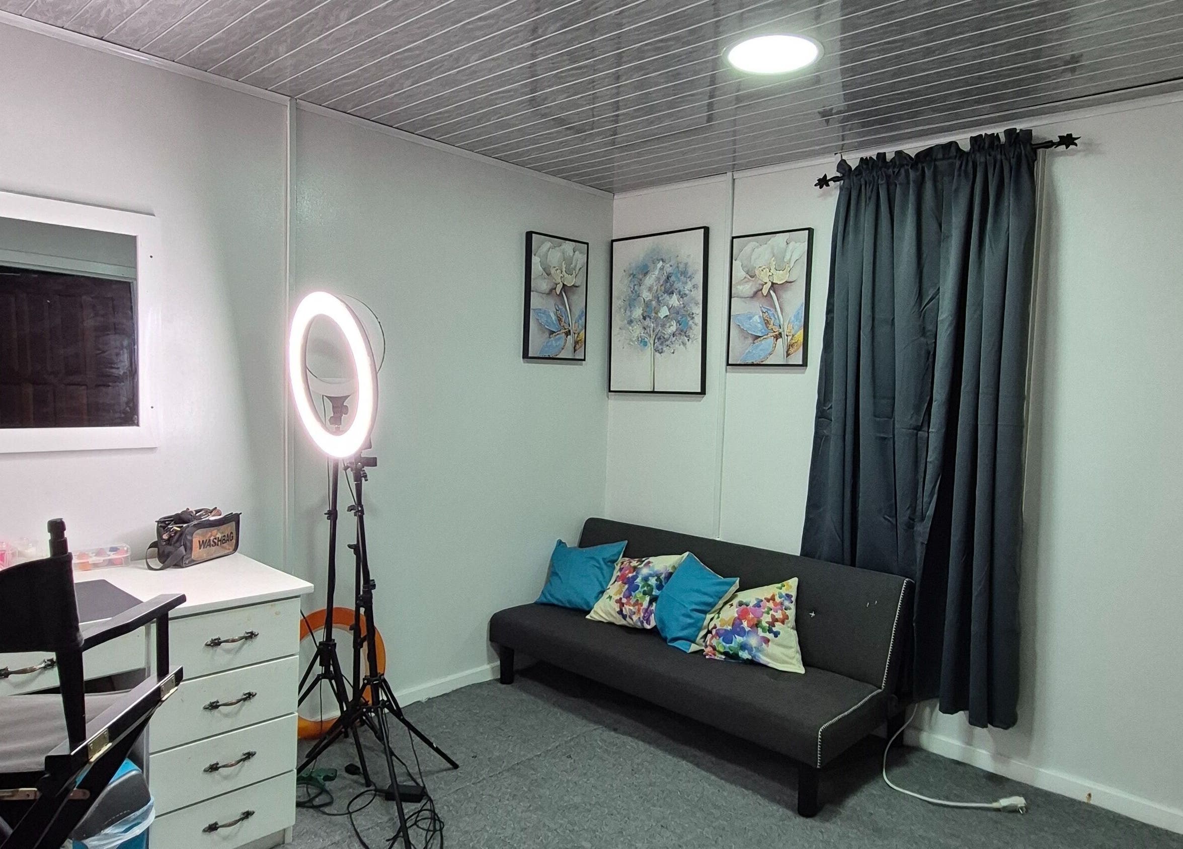 Bright makeup station at Exotic Beats Makeup Studio, Georgetown, GY, with ring light and art decor.