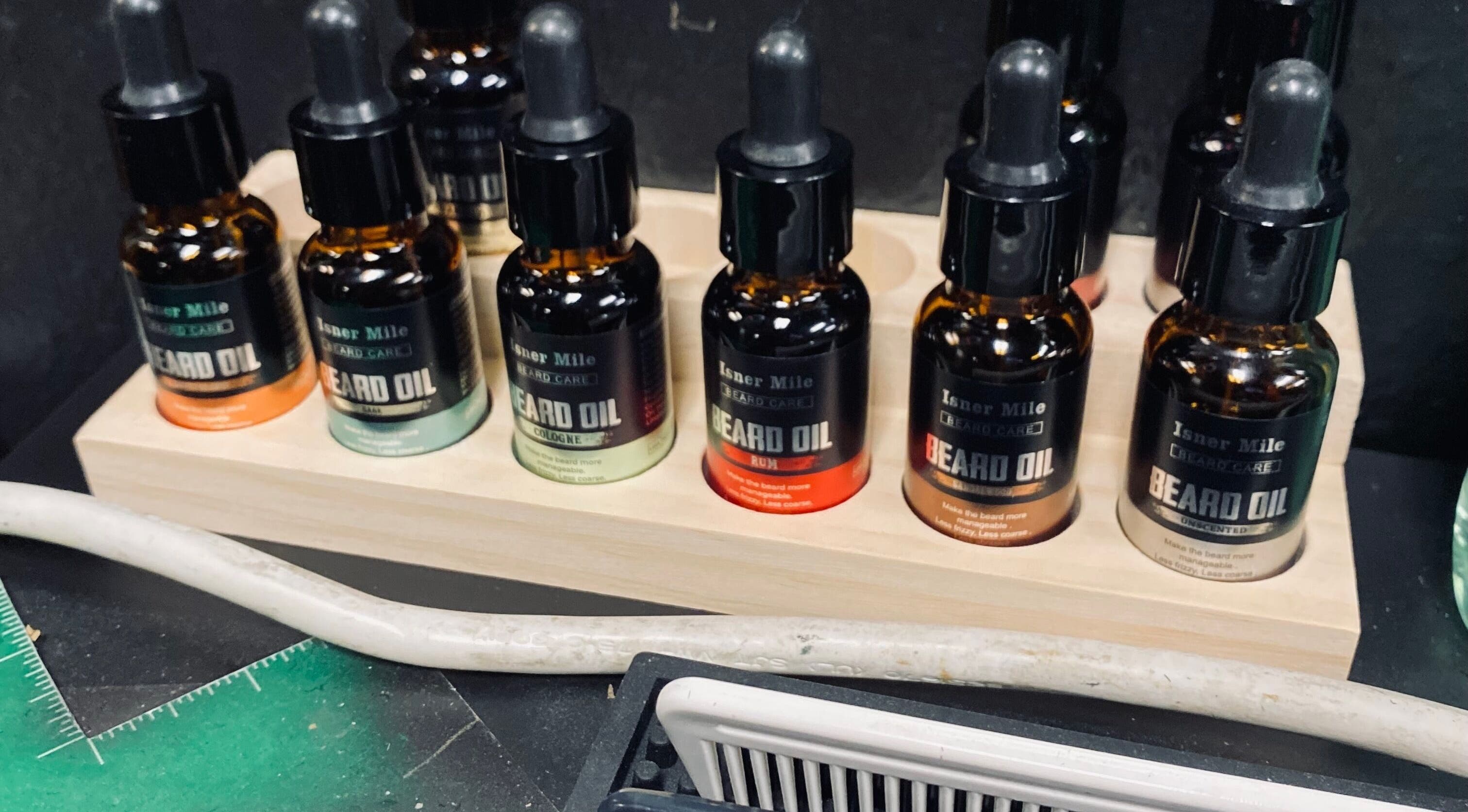 BONE | BARBER + SMP in Spring, Texas, US showcases a selection of premium beard oils on a wooden stand.
