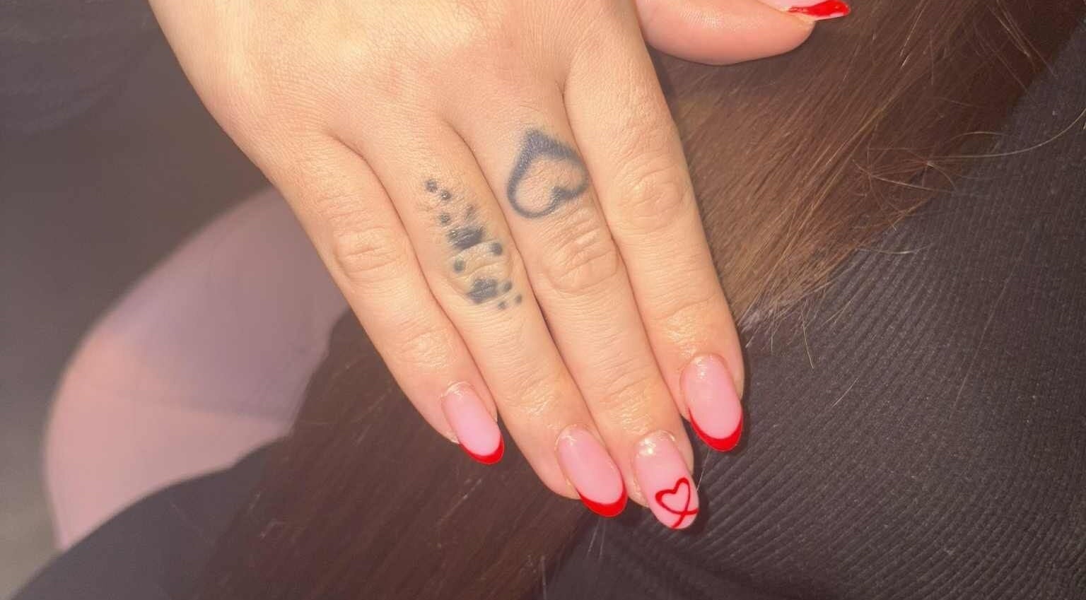 Elegant red-trimmed nails with heart design at NailsbyStormx, Peterborough, England, GB.