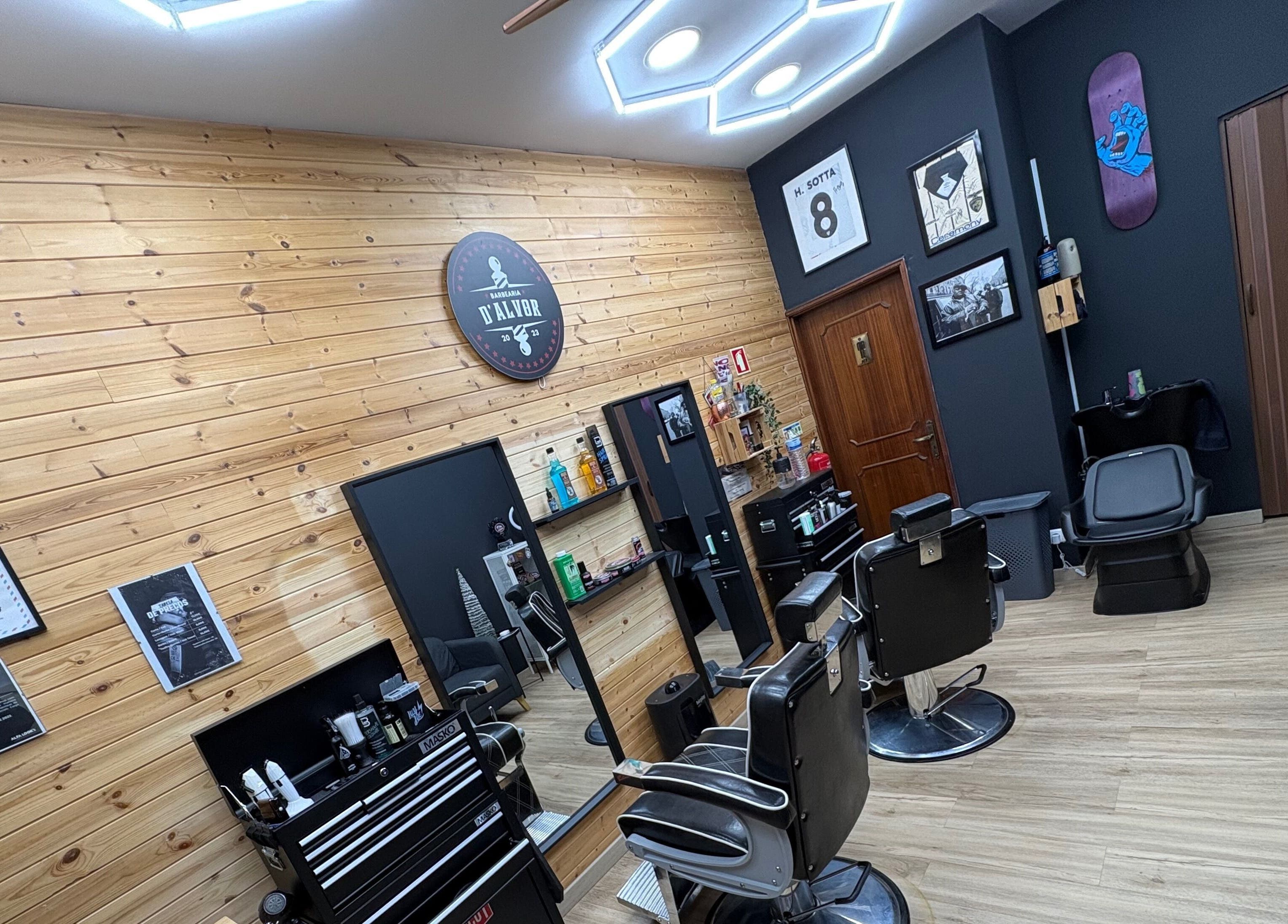 Interior moderno da Barbearia D'Alvor em Alvor, Faro, PT com cadeiras de barbear preto e decoração elegante.