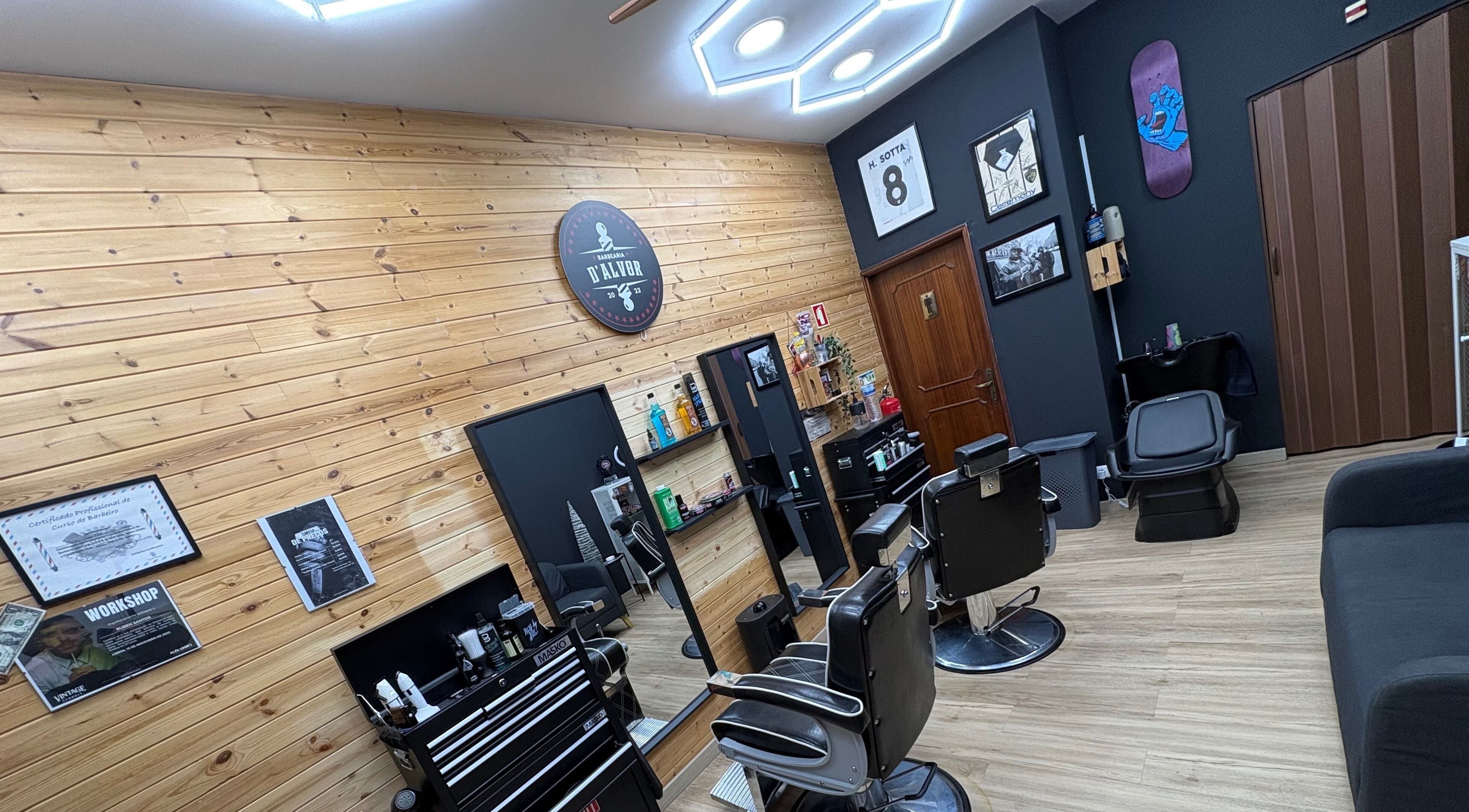 Interior moderno da Barbearia D'Alvor em Alvor, Faro, PT com cadeiras de barbear preto e decoração elegante.