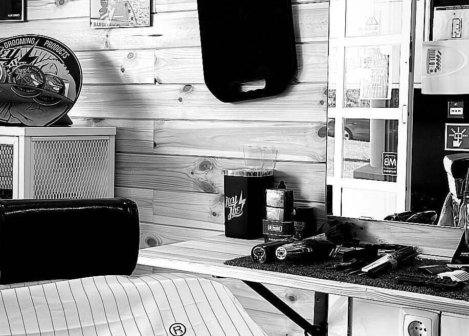 Interior da Barbearia D'Alvor em Alvor, Faro, PT com produtos de grooming e decoração elegante.