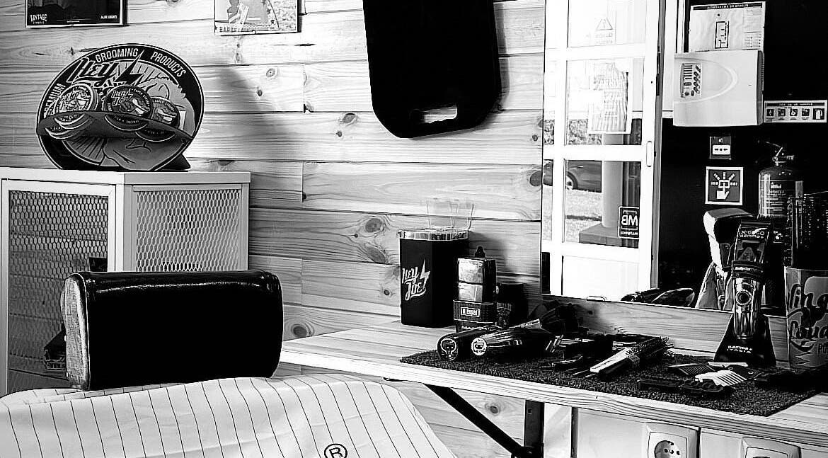 Interior da Barbearia D'Alvor em Alvor, Faro, PT com produtos de grooming e decoração elegante.