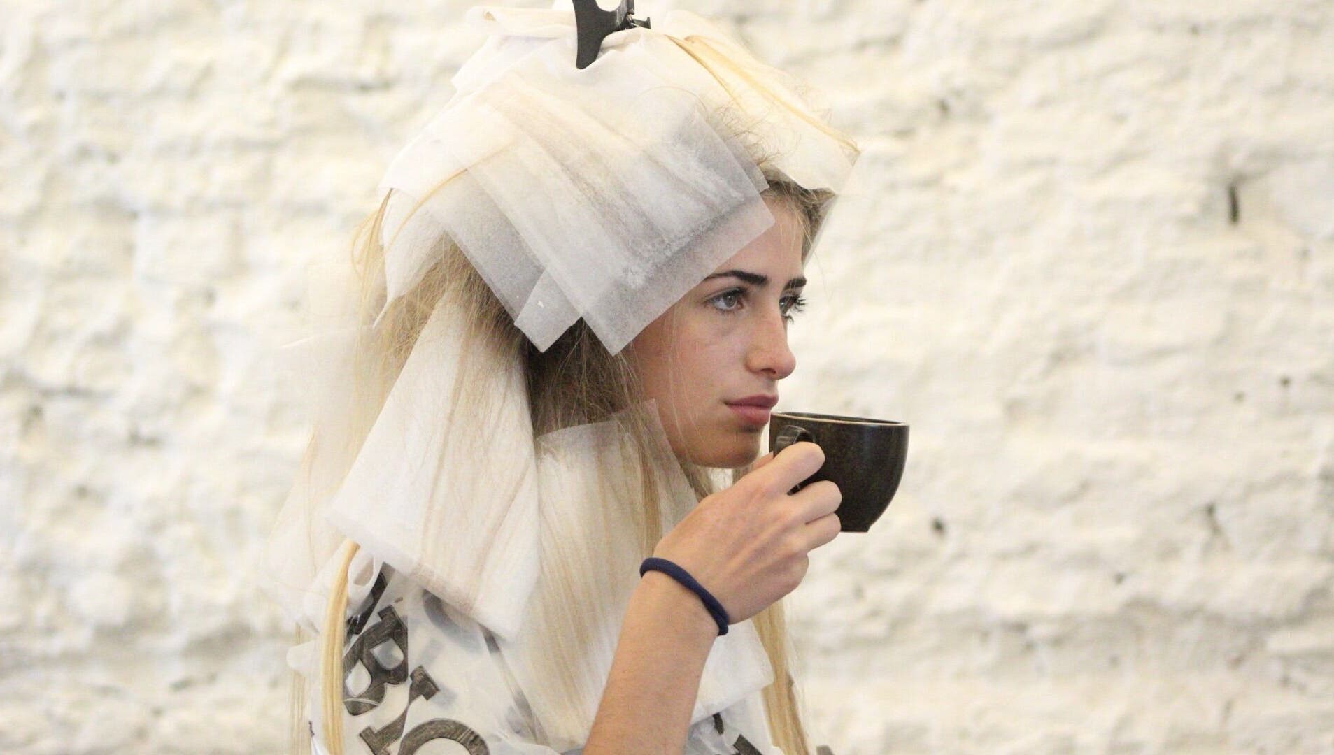 Mujer tomando té durante sesión de peluquería en Peluqueria 502, Gonnet, Provincia De Buenos Aires, AR.