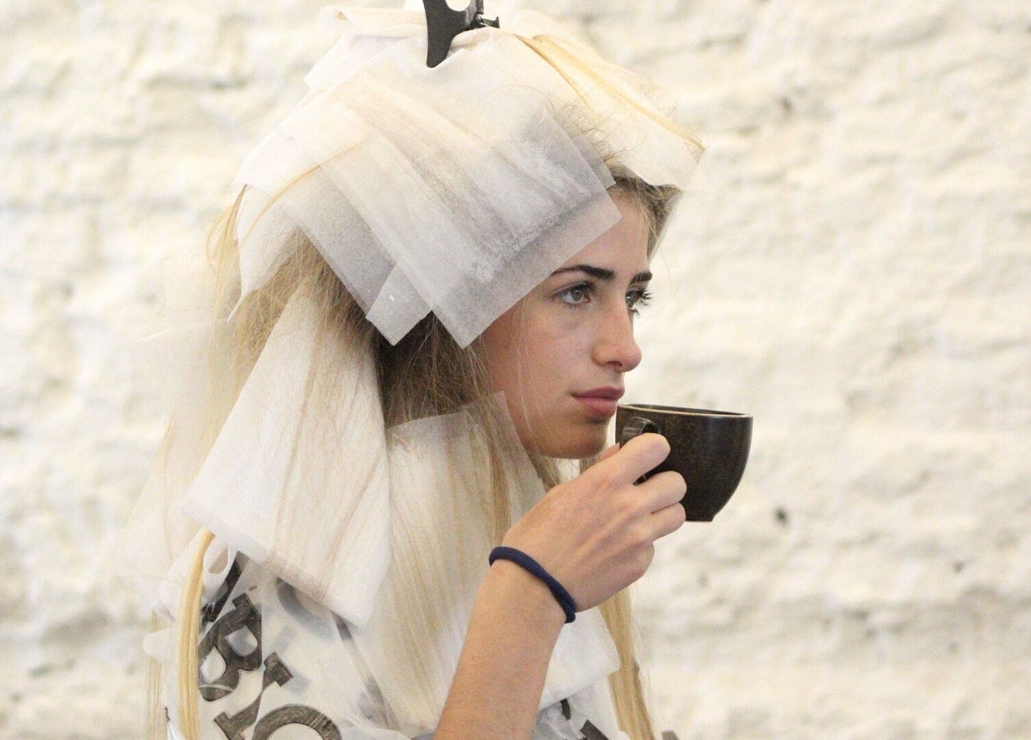 Mujer tomando té durante sesión de peluquería en Peluqueria 502, Gonnet, Provincia De Buenos Aires, AR.