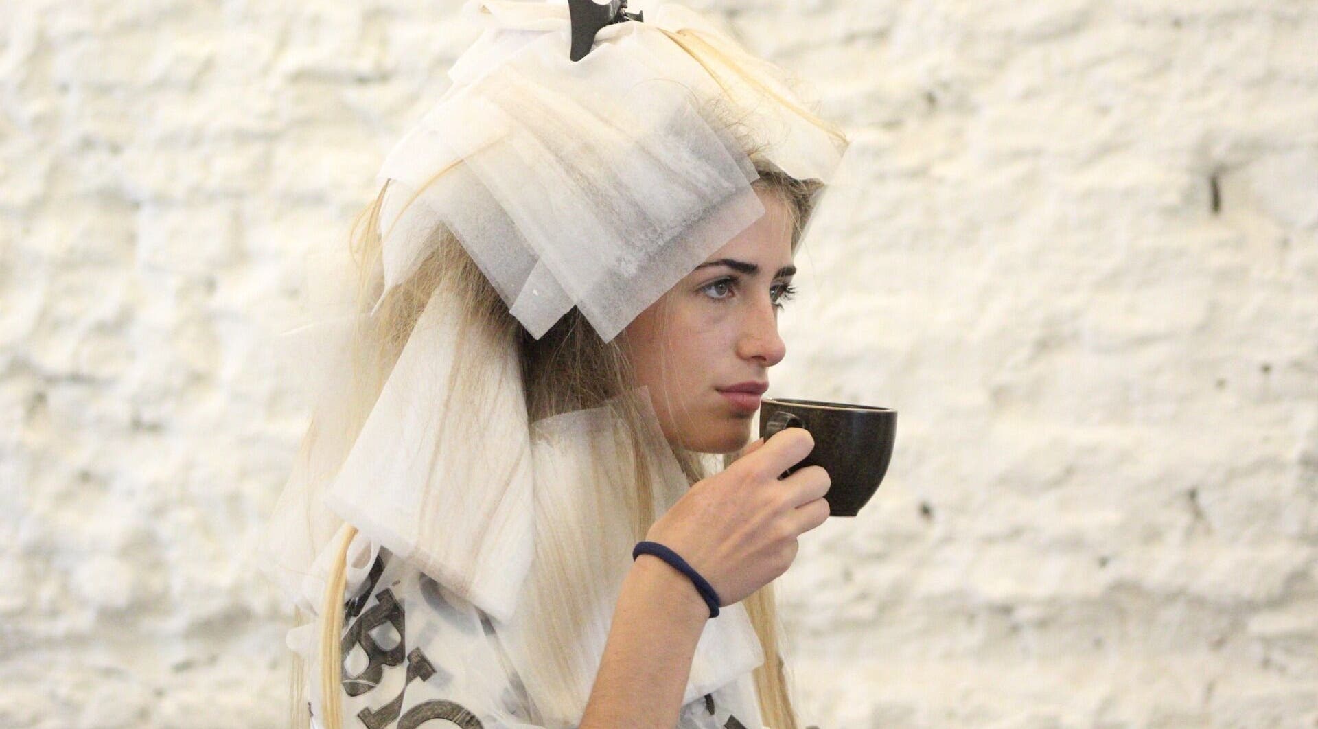 Mujer tomando té durante sesión de peluquería en Peluqueria 502, Gonnet, Provincia De Buenos Aires, AR.