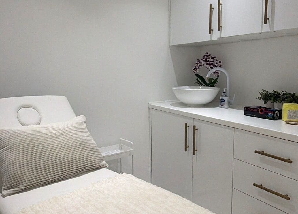 Calming treatment room at Aura Skinn By Sandra, Buckhurst Hill, England, GB with a plush bed and elegant decor.