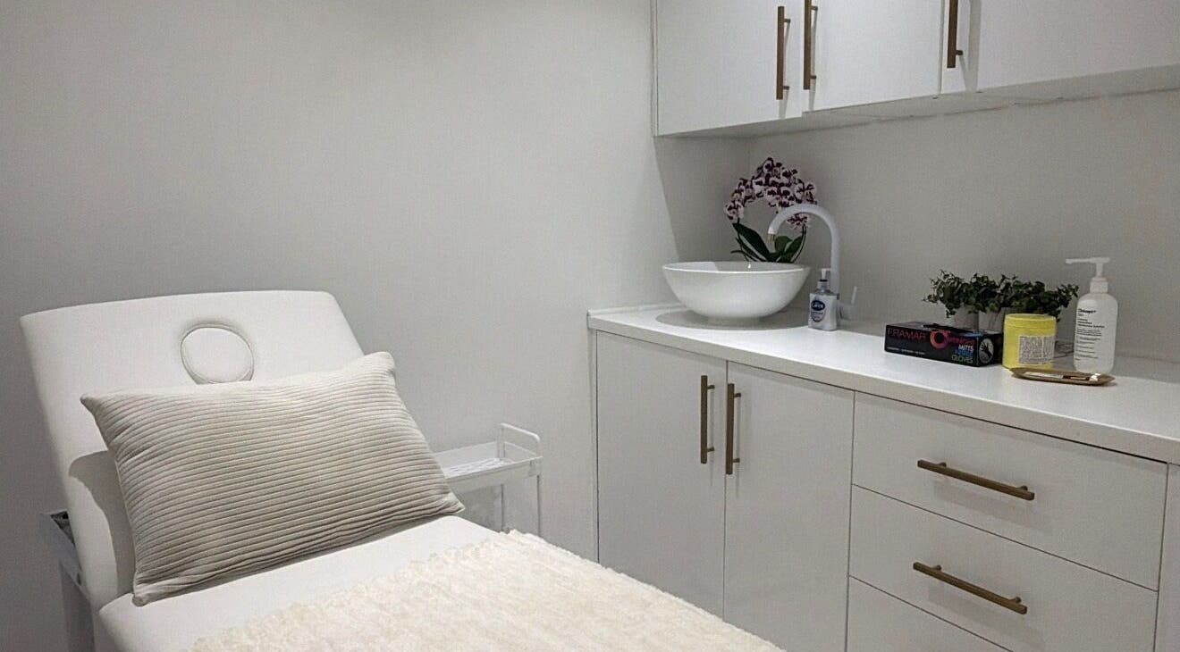 Serene treatment room at Aura Skinn By Sandra, Buckhurst Hill, England, GB. Features modern decor and a cozy bed.